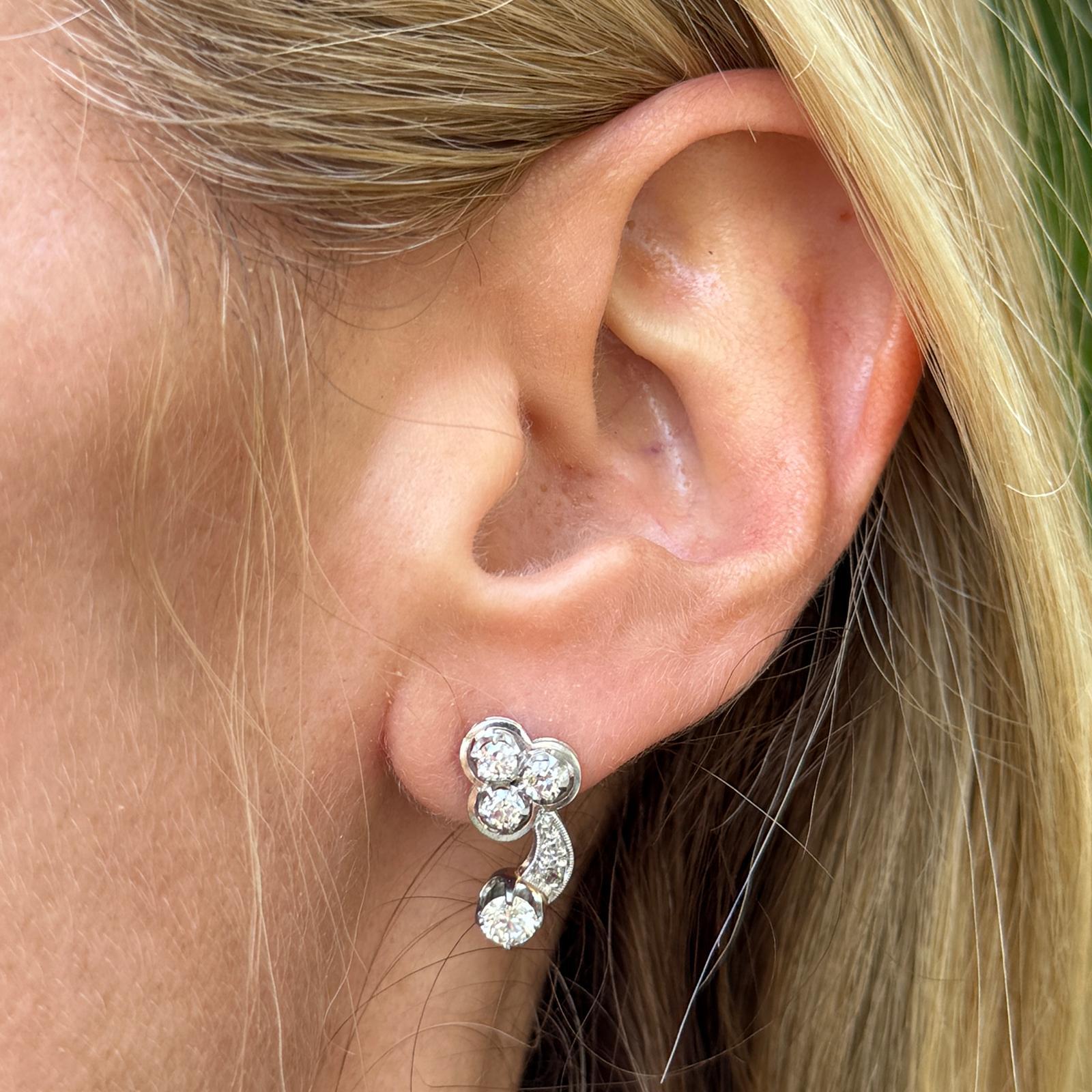 These stunning 1950s vintage diamond earrings feature a classic and elegant design, showcasing 12 round brilliant cut diamonds totaling approximately 1.16 carats (G-H color, SI clarity). The diamonds are set in 14K white gold, enhancing their