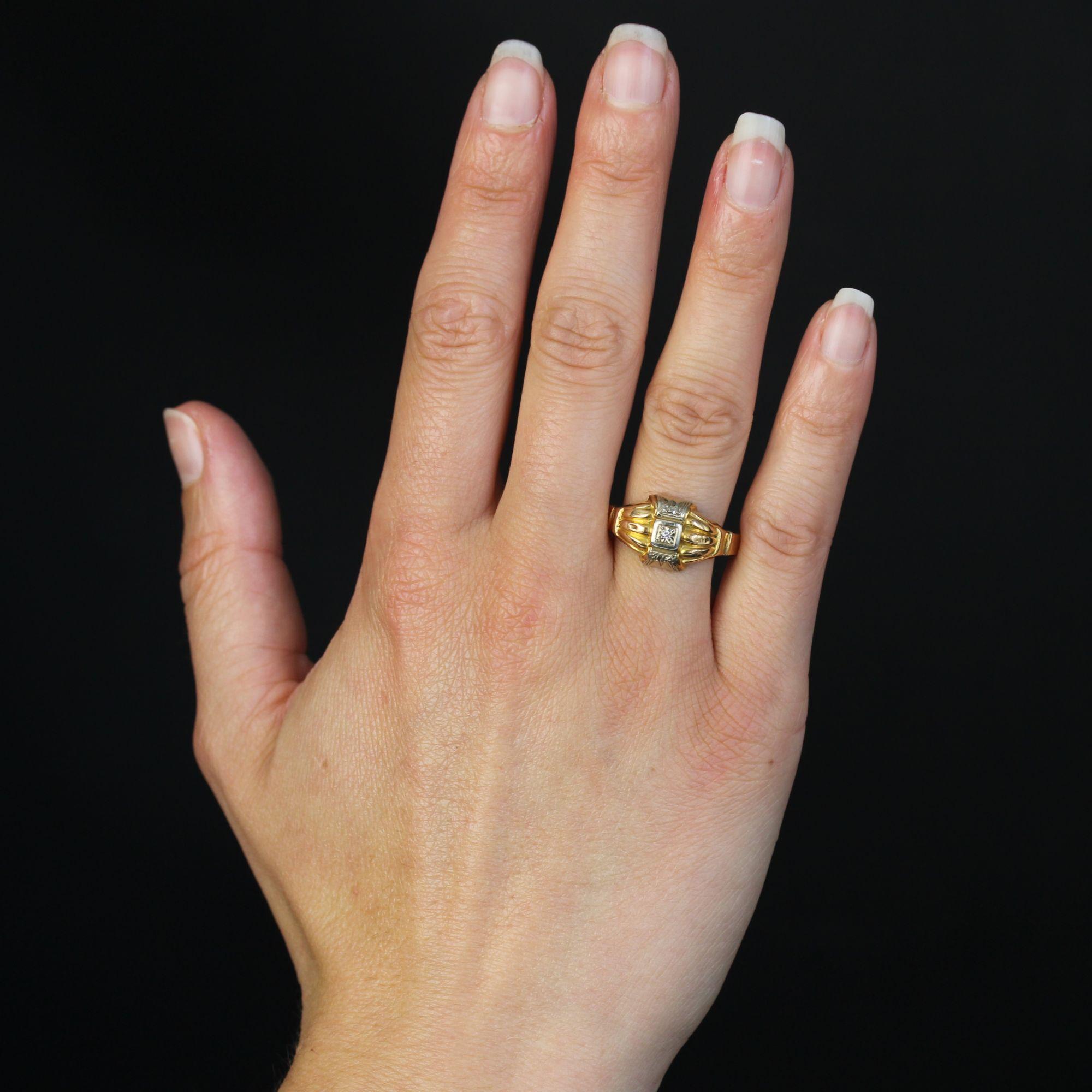 Bague en or jaune 18 carats.
Bague ancienne ornée de part et d'autre de godrons légèrement bombés en or jaune et au centre de motifs géométriques en or blanc, le motif central retenant un diamant en serti clos.
Hauteur : 11,3 mm, largeur : 18,5 mm,