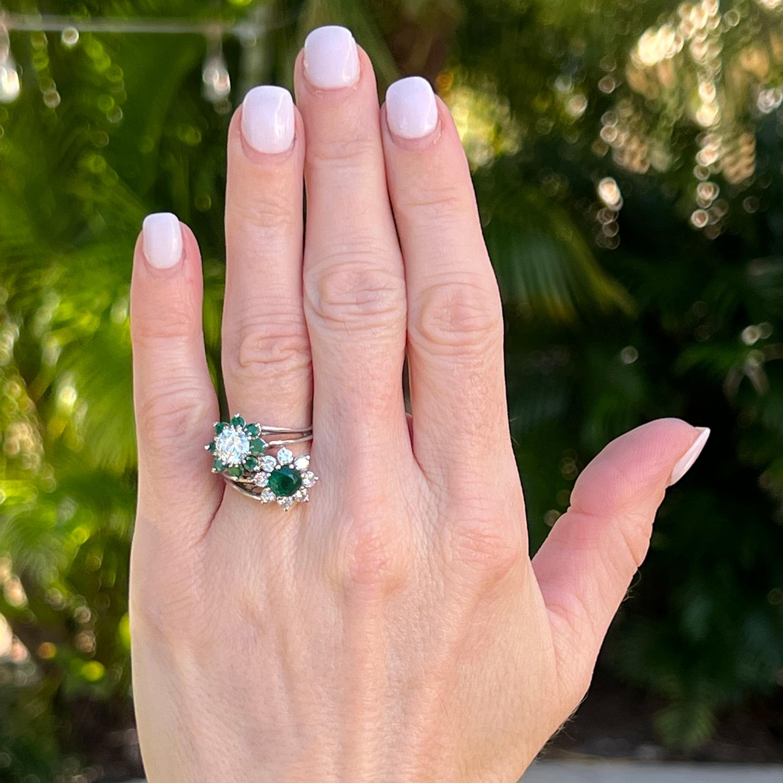 Beautiful and unique vintage diamond emerald bypass ring handcrafted in 18 karat white gold. The ring features an approximately .90 carat round brilliant cut diamond and an approximately 1.25 carat round cut emerald that are set in the centers. The