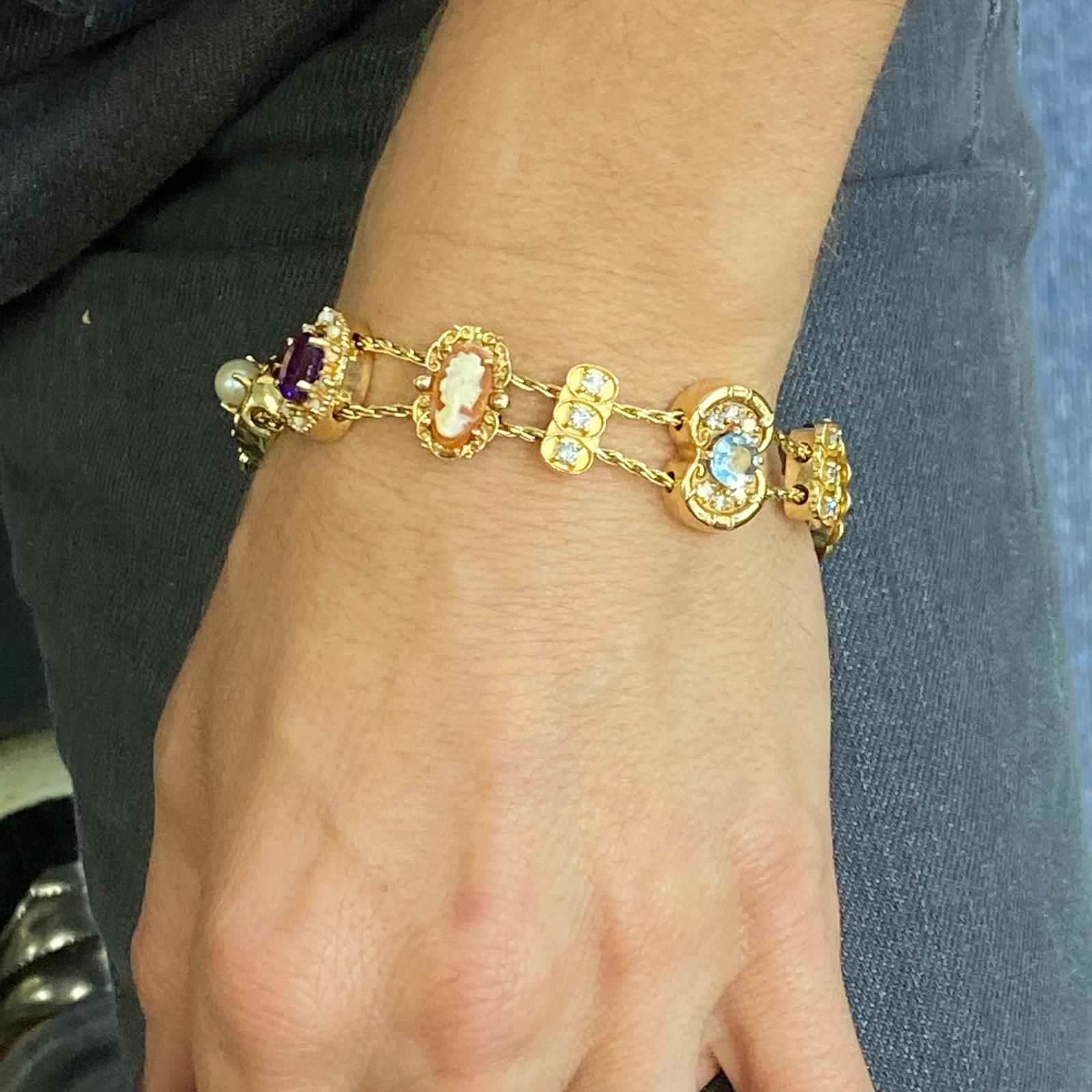 Vintage slide bracelet fashioned in 14 karat yellow gold. The bracelet features slides containing 12 round brilliant cut diamonds throughout weighing .50 carat total weight,  as well as amethyst, opal, emerald, ruby, and sapphire gemstones. The