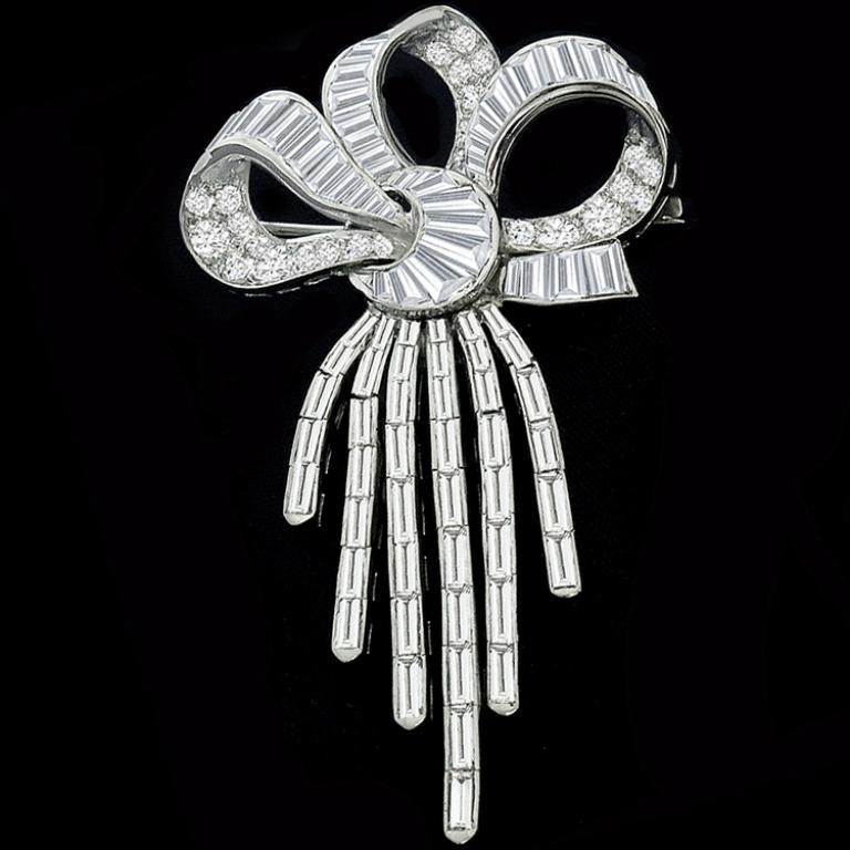 This wonderful platinum diamond bow pin/ pendant is set with high quality sparkling round and baguette cut diamonds that weighs approximately 6.00ct. graded F-G color with VS clarity. The pin can also be worn as pendant.
It measures 59mm by 33.5mm