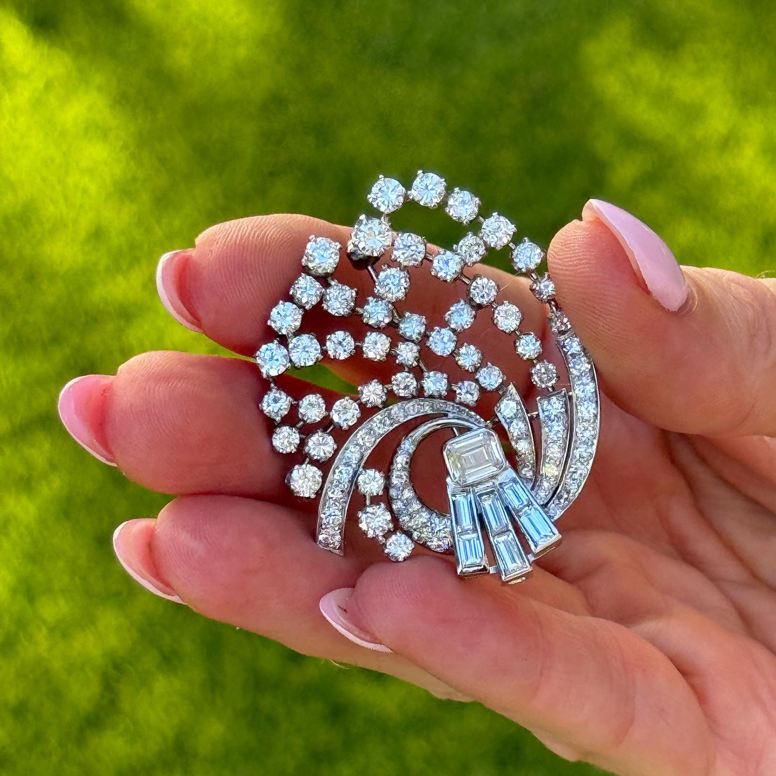 Vintage platinum diamond swirl brooch, showcasing an elegant, sculptural design with fluid, sweeping curves. The piece is adorned with 43 round brilliant-cut diamonds totaling approximately 1.50 carats, six baguette-cut diamonds totaling 0.72