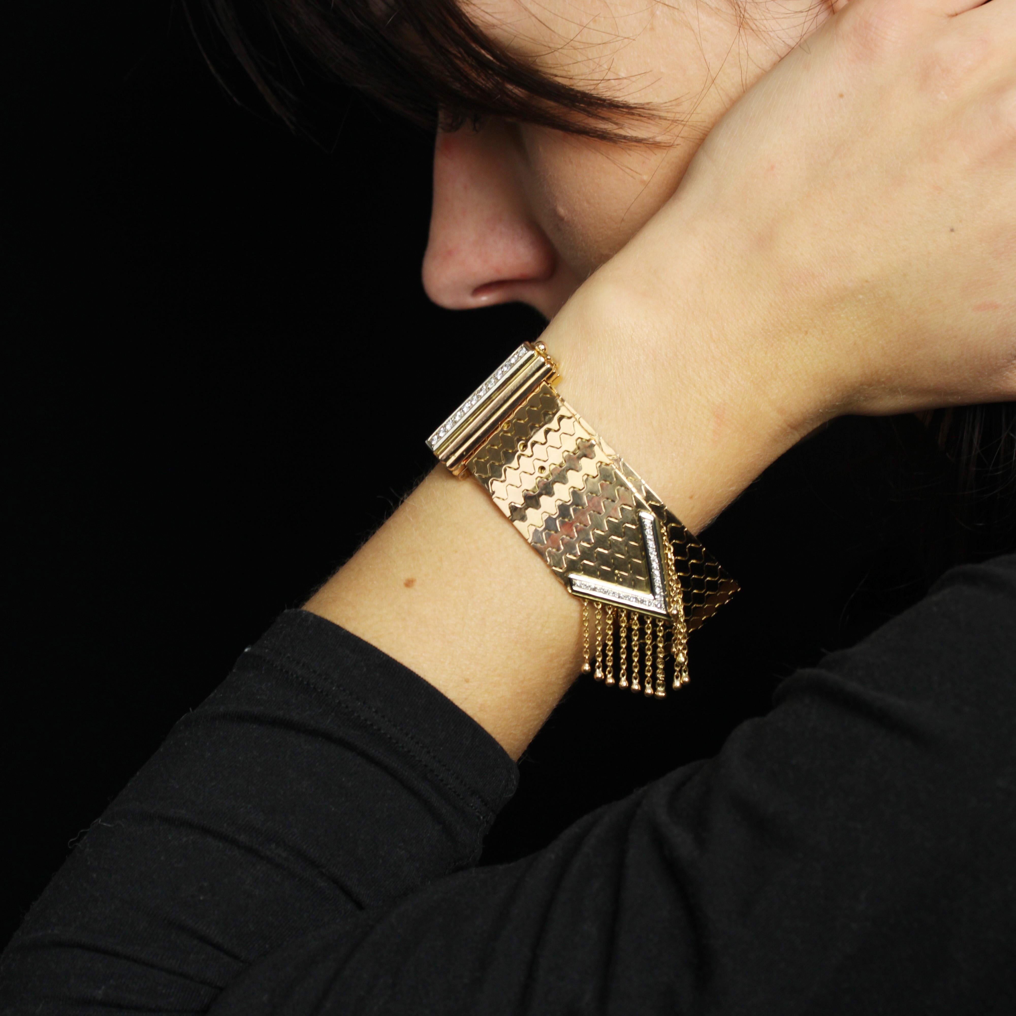 Bracelet in 18 karat yellow gold.
Sublime vintage yellow gold bracelet. It is supple and forms a belt of articulated wave motifs. Some links are pierced to accommodate the clasp, which forms a pin buckle. The latter forms a fluted dome, adorned at