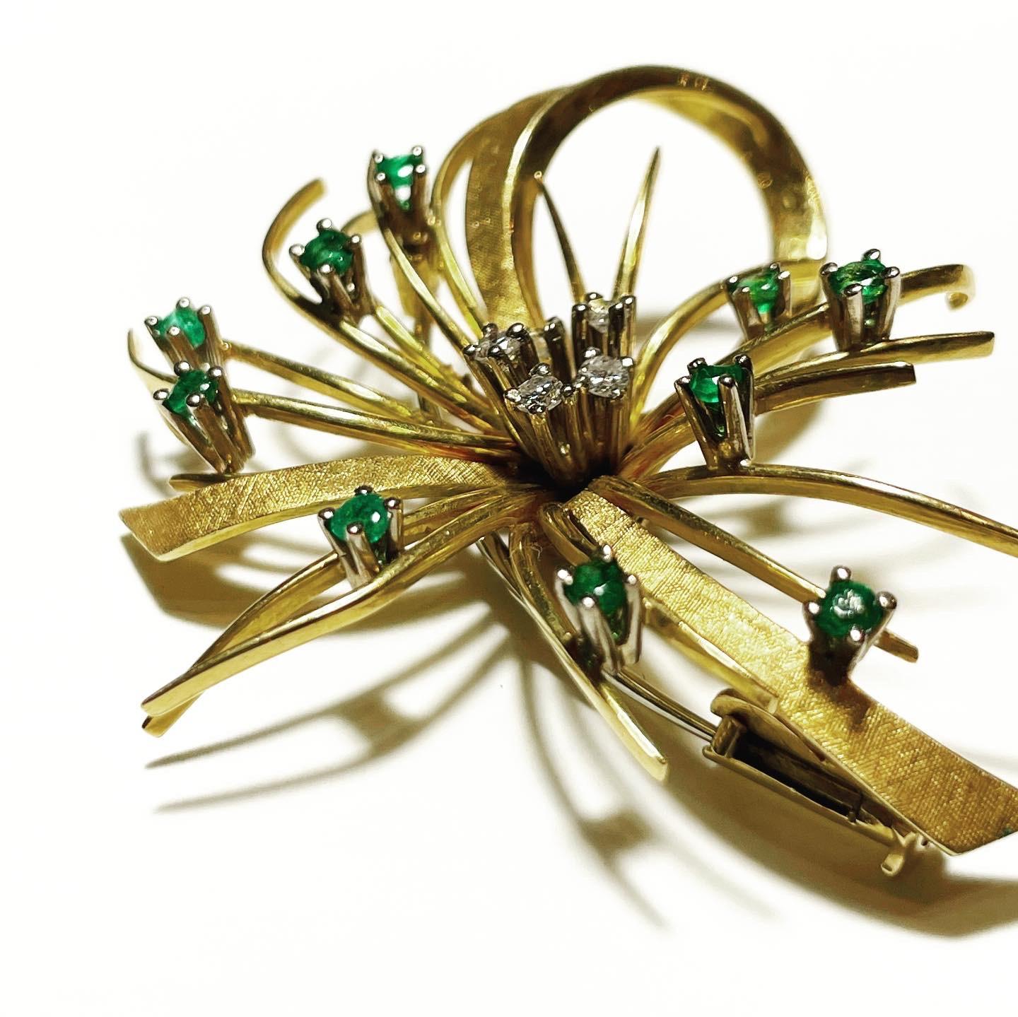1950s Diamonds and Emeralds nuanced 18k yellow gold stylized ribbon brooch, 
Total approximate weight of the diamonds:  0.2 carat.
Total approximate weight of the emeralds:  0.5 carat.
Total weight of the jewel: 13 g.
Perfect condition.

FREE