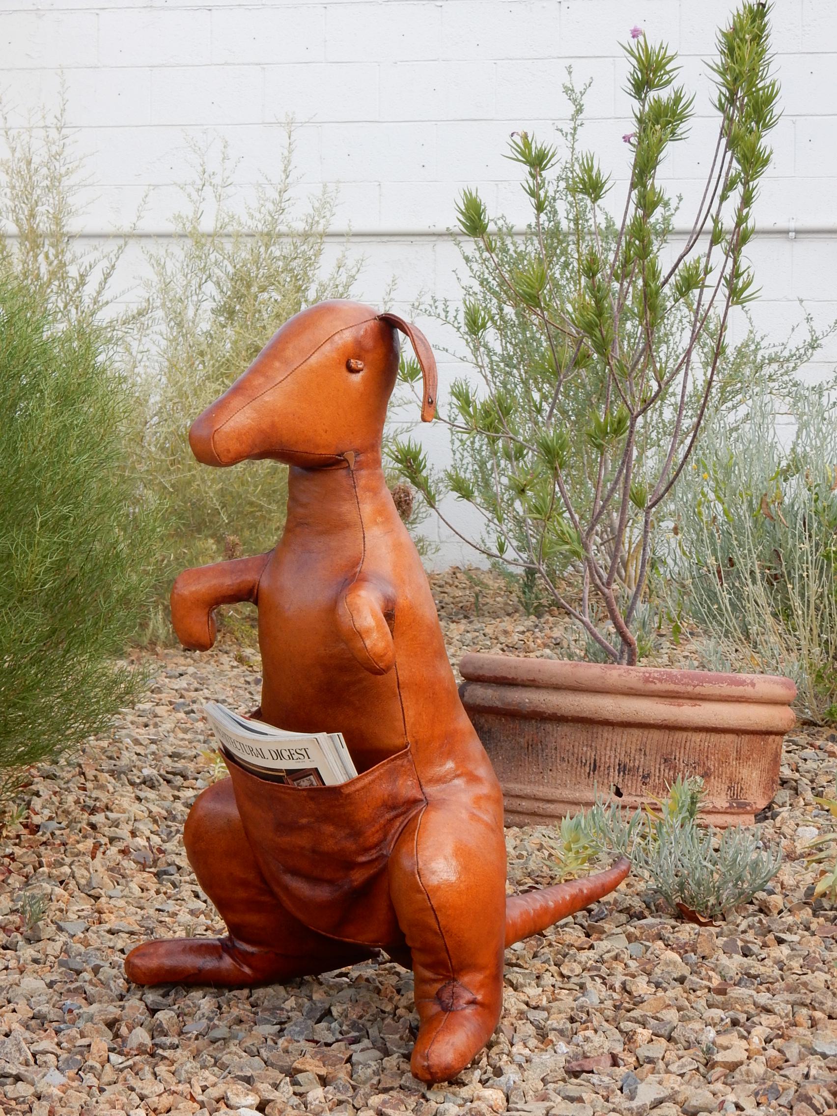 Midcentury Dimitri Omersa leather kangaroo sculpture magazine holder.
Adds a whimsical charm to any decorum.
Holds 4 or 5 standard magazines with ease,
circa 1950s caramel color leather, showing 60+ years of aged patina and charm including few