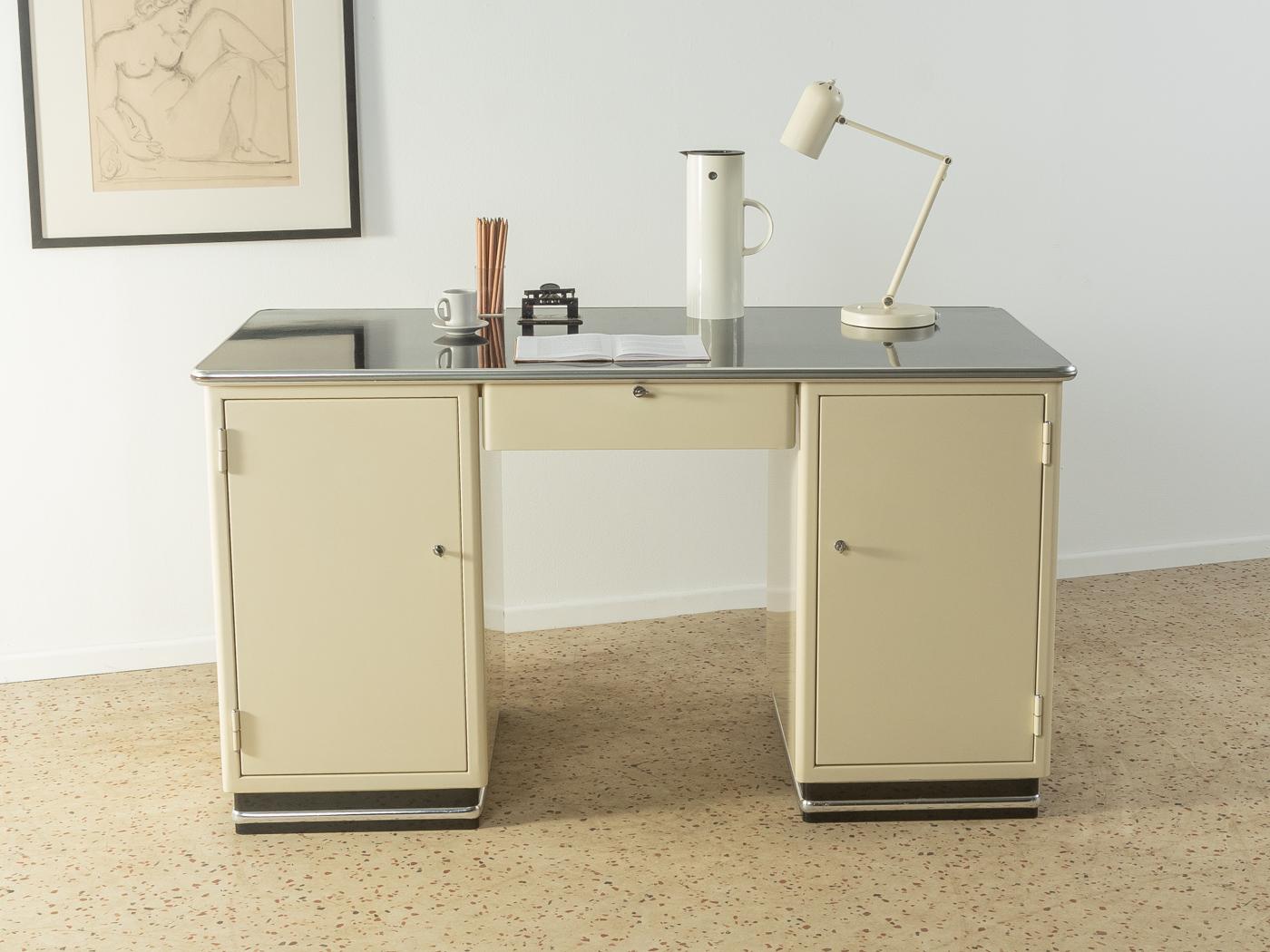 Classic doctor’s desk from the 1950s. Cream white metal body with one drawer, two cabinet doors, six internal drawers, a worktop with black Formica and a black base with chrome trim.

Quality Features:
very good workmanship
high-quality