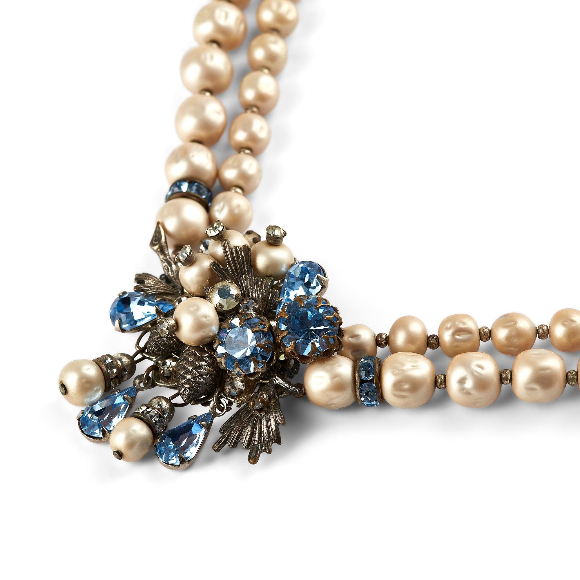 This original late 1940s to early 1950s necklace is a truly eye-catching piece and is possibly an unsigned early Miriam Haskell piece designed by Frank Hess. Two strings of faux baroque pearls are crowned with a central decoration composed of an