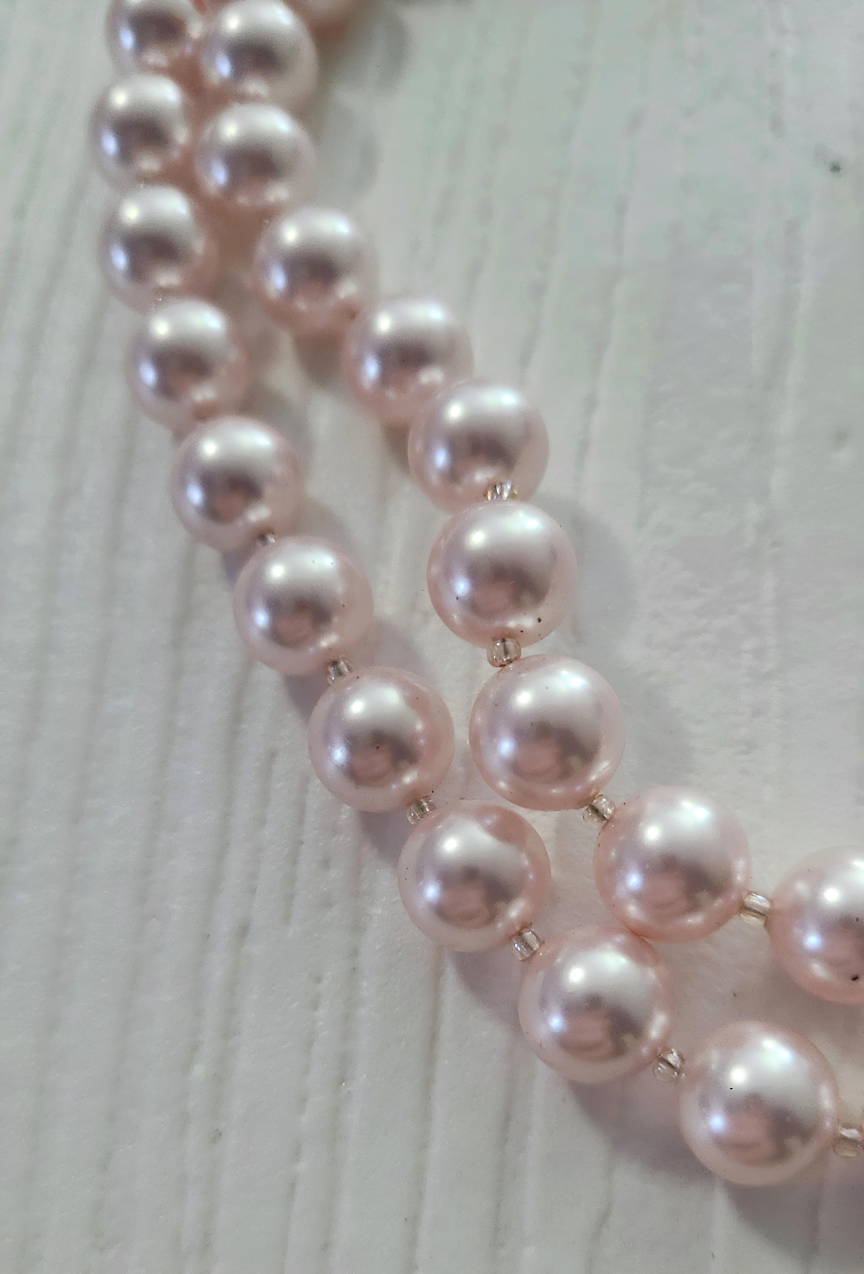 Double stranded pink freshwater pearls, carefully separated by individual translucent glass seed beads, gathered at either end 
with pink lace & velvet tie-up closure. 

Freshwater pearls are real, cultured pearls that are grown in lakes, rivers,
