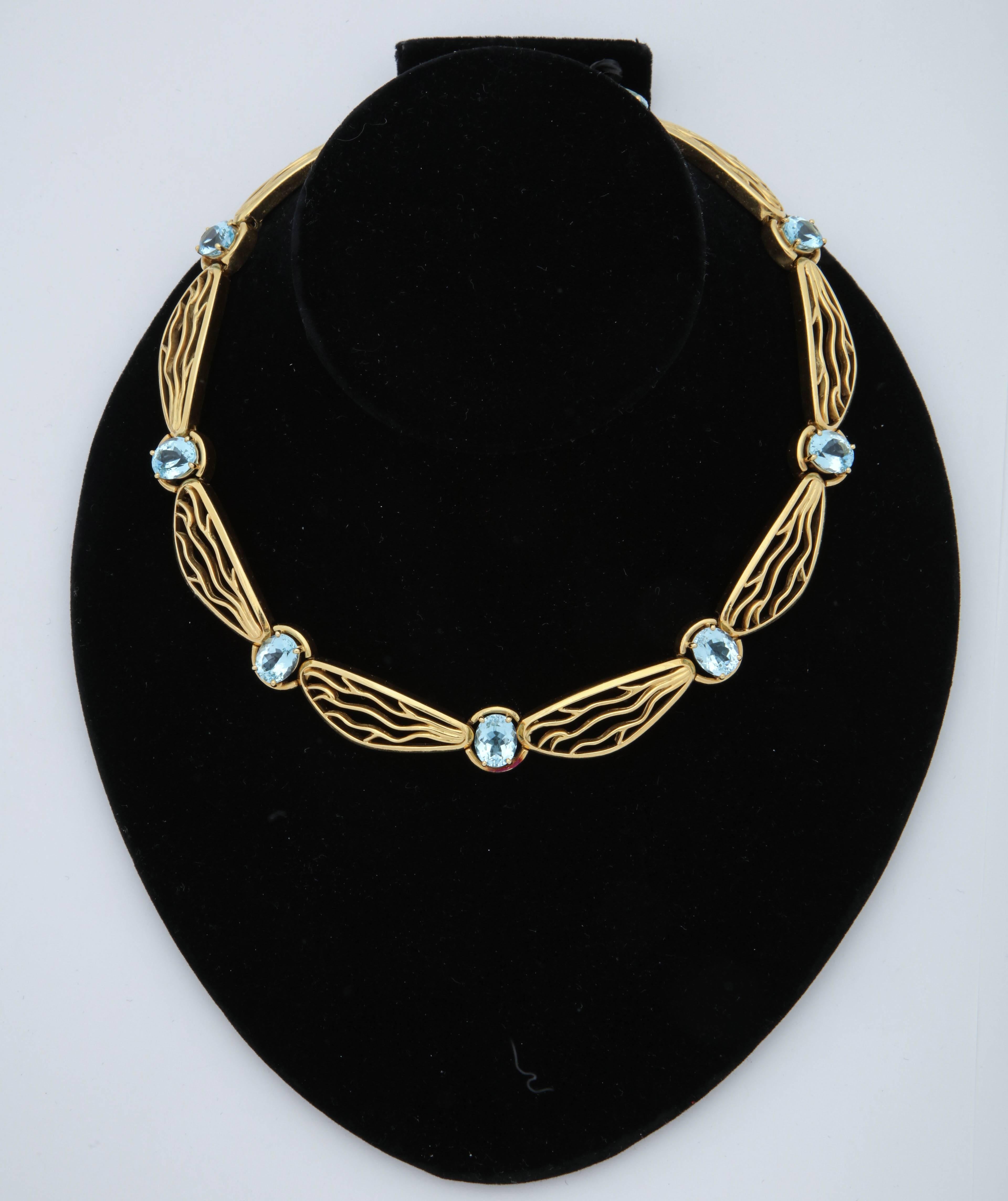 One Ladies Very Interesting and Unusual Heavy 18kt Yellow Gold Necklace In which The Gold Craftmanship Is Emulating DragonFly Wings Thruout The Design Of the Necklace.This Choker style Necklace Is embellished With Nine Delicate Prong Set  Oval Cut