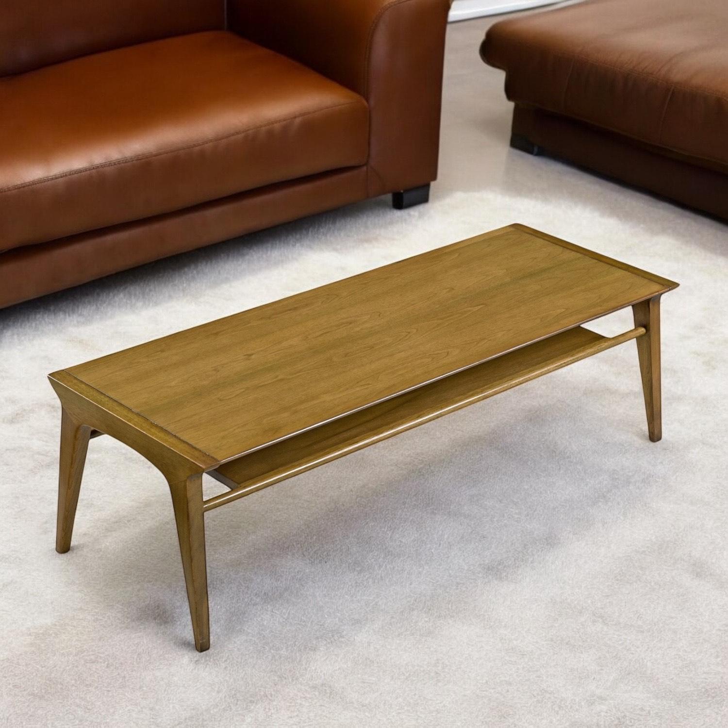 Drexel Profile Cocktail- oder Couchtisch aus Nussbaum und Pekannuss, Modell K92, ca. 1950er Jahre.  Die rechteckige, flache und stromlinienförmige Tischplatte hat eine ausgeprägte, vertiefte Ablagefläche, die auf abgewinkelten, quadratischen und