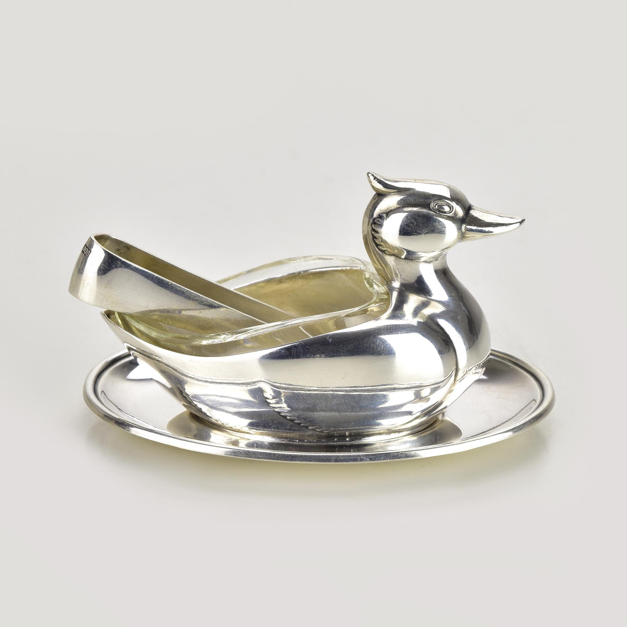 Charmante et fantaisiste boîte à sel ou à épices en forme de canard en argent 0.800 par Jetzler, Suisse, vers les années 1950. Ce ravissant accessoire de table figuratif représente un canard finement sculpté, avec un couvercle en verre amovible et