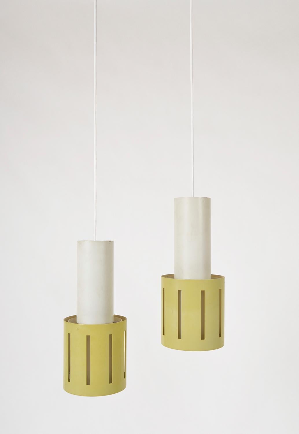 A very stylish pair of Dutch 1950s Mid-Century Modern pastel yellow cylindrical 'Hand Grenade' pendant lights. Hung from their original two piece steel ceiling rose, the wire runs down to a bulb holder located inside the white metal cylinder where