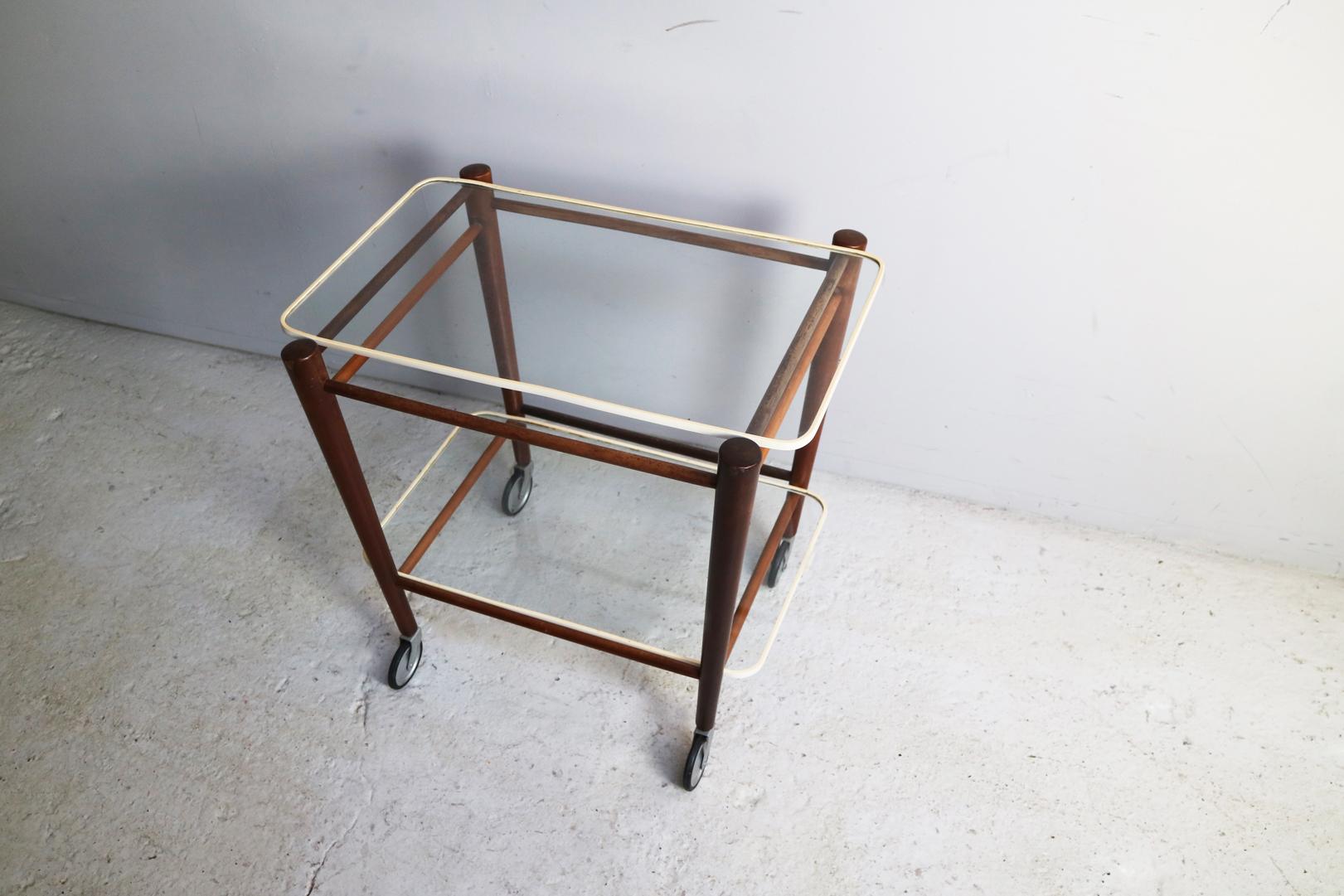 A beautiful serving trolley in its original state by renowned Dutch designer Cees Braakman and produced by UMS Pastoe in the 1950s.

The trolley has a solid teak frame and two un-fixed glass shelves with the original rubber edge protection. The