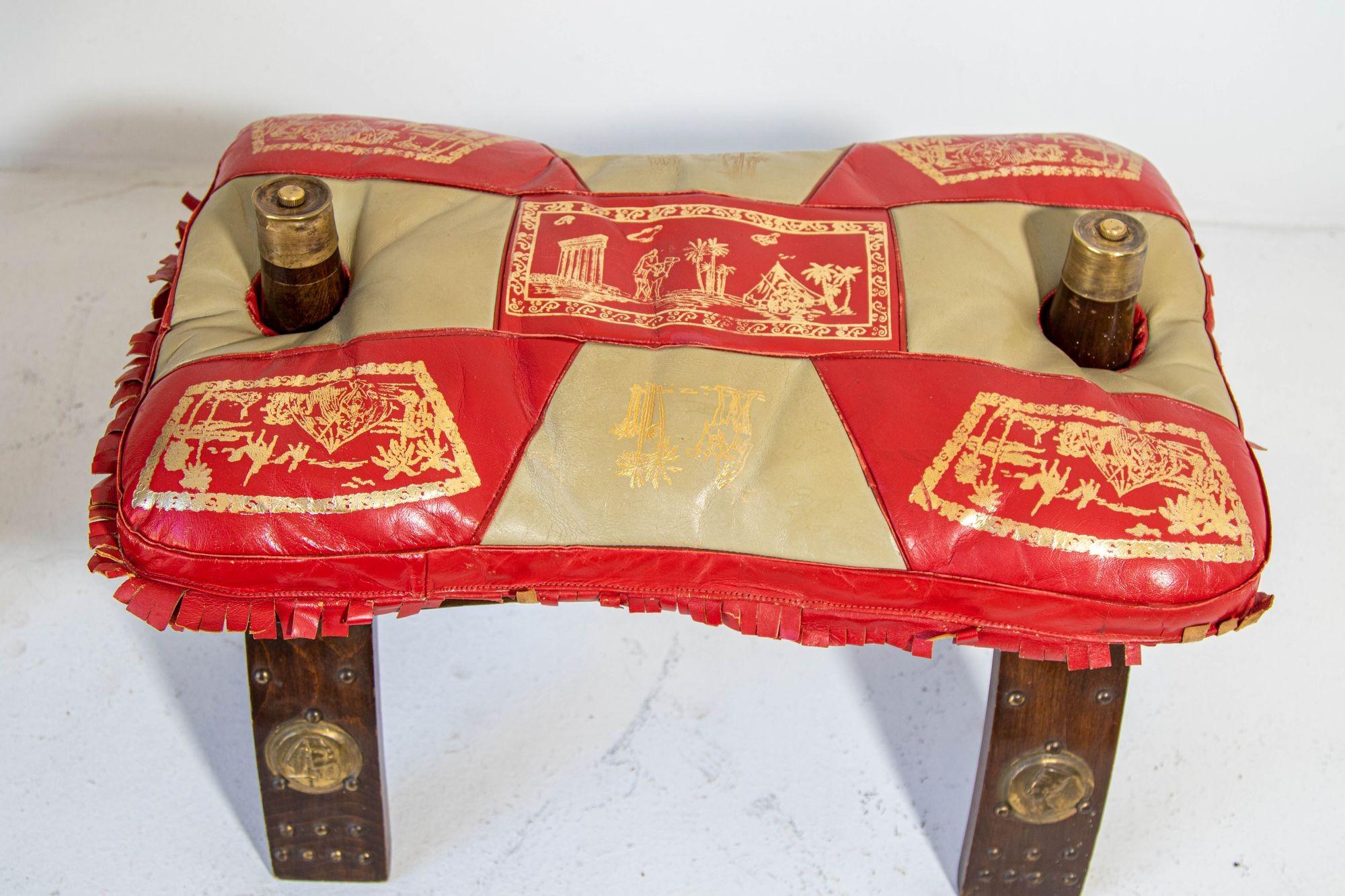 1950s Vintage Egyptian, North Africa camel saddle shape stool.
A middle eastern wood and leather camel saddle wood bench designed with a wooden frame and a red and gold leather cushion seat.
Traditionally used to ride camels in the desert of Africa