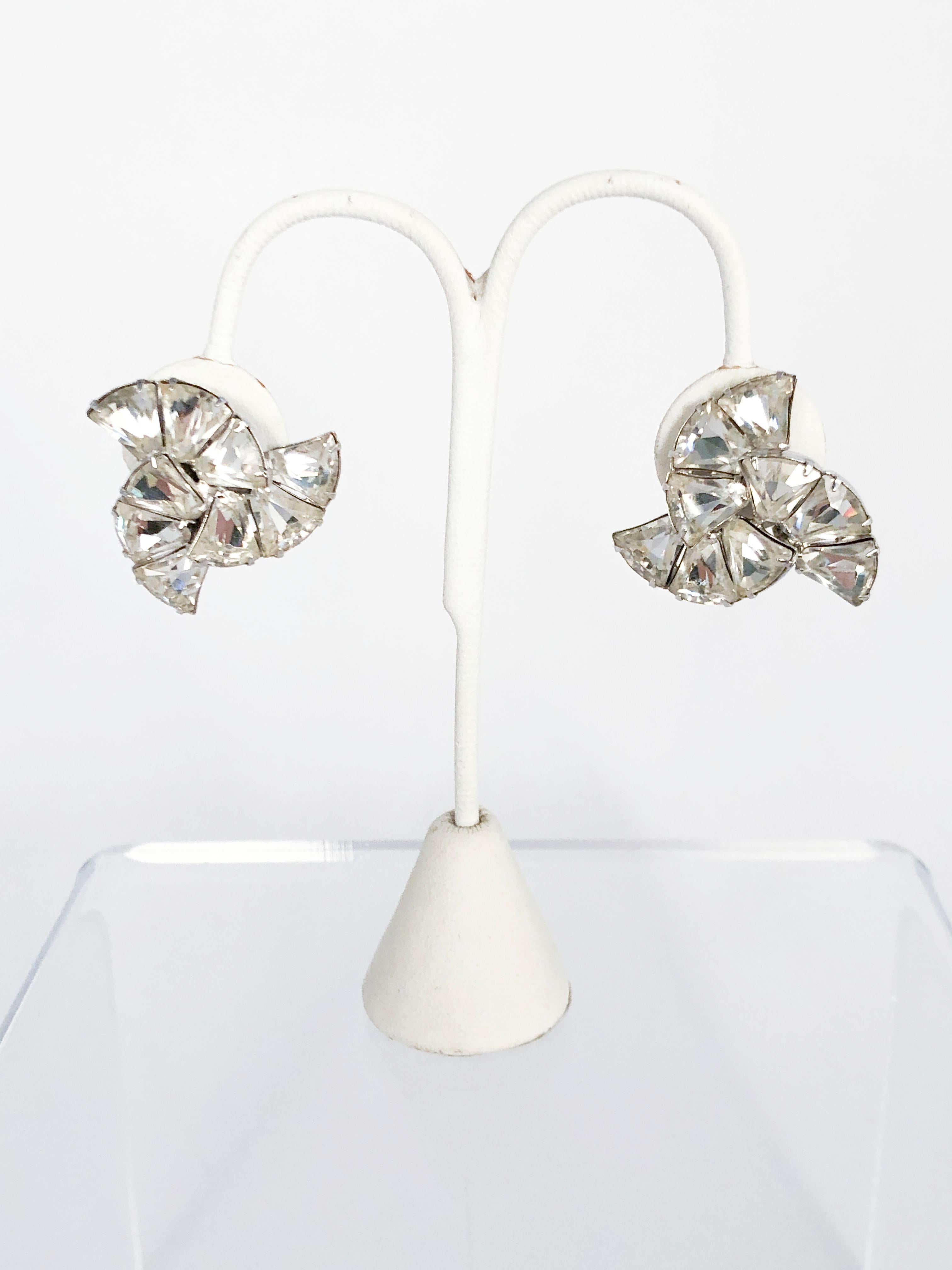 1950s eisenberg clip-on earring and brooch set with large clear rhinestones cut in various shapes. They are configured into a triangular shape and set in a silver-washed base metal. The back of the brooch has a standard brooch pin and clearly