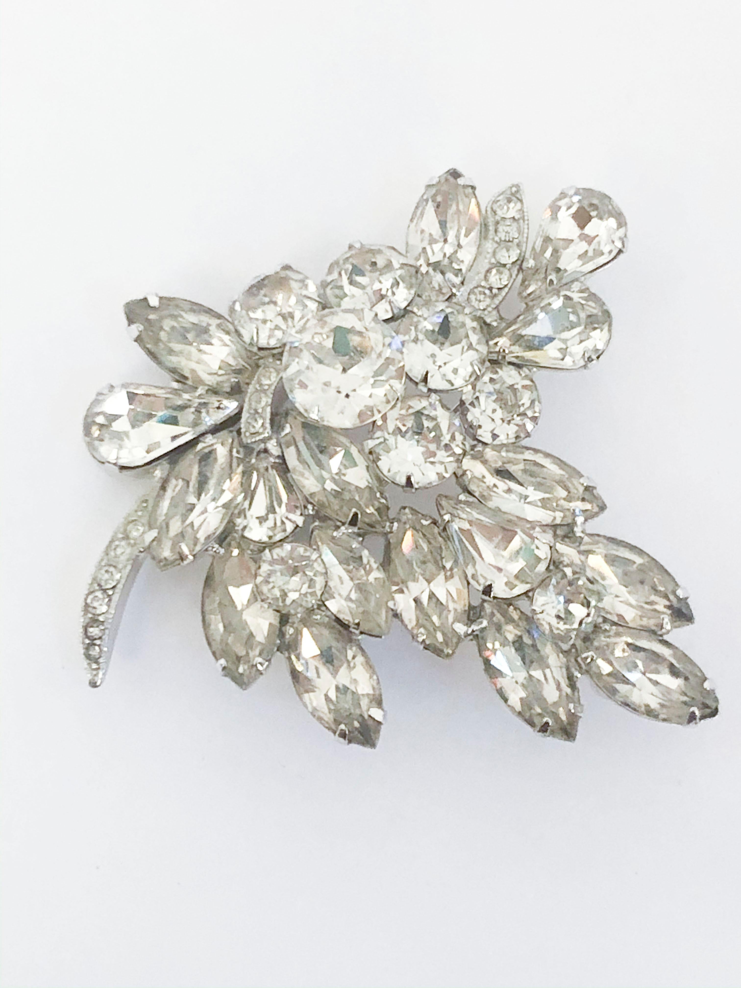 1950s Eisenberg brooch featuring enlarged clear rhinestones with varying cuts. The setting metal has a brilliant silver wash and the back has a standard brooch pin and is hallmarked with 