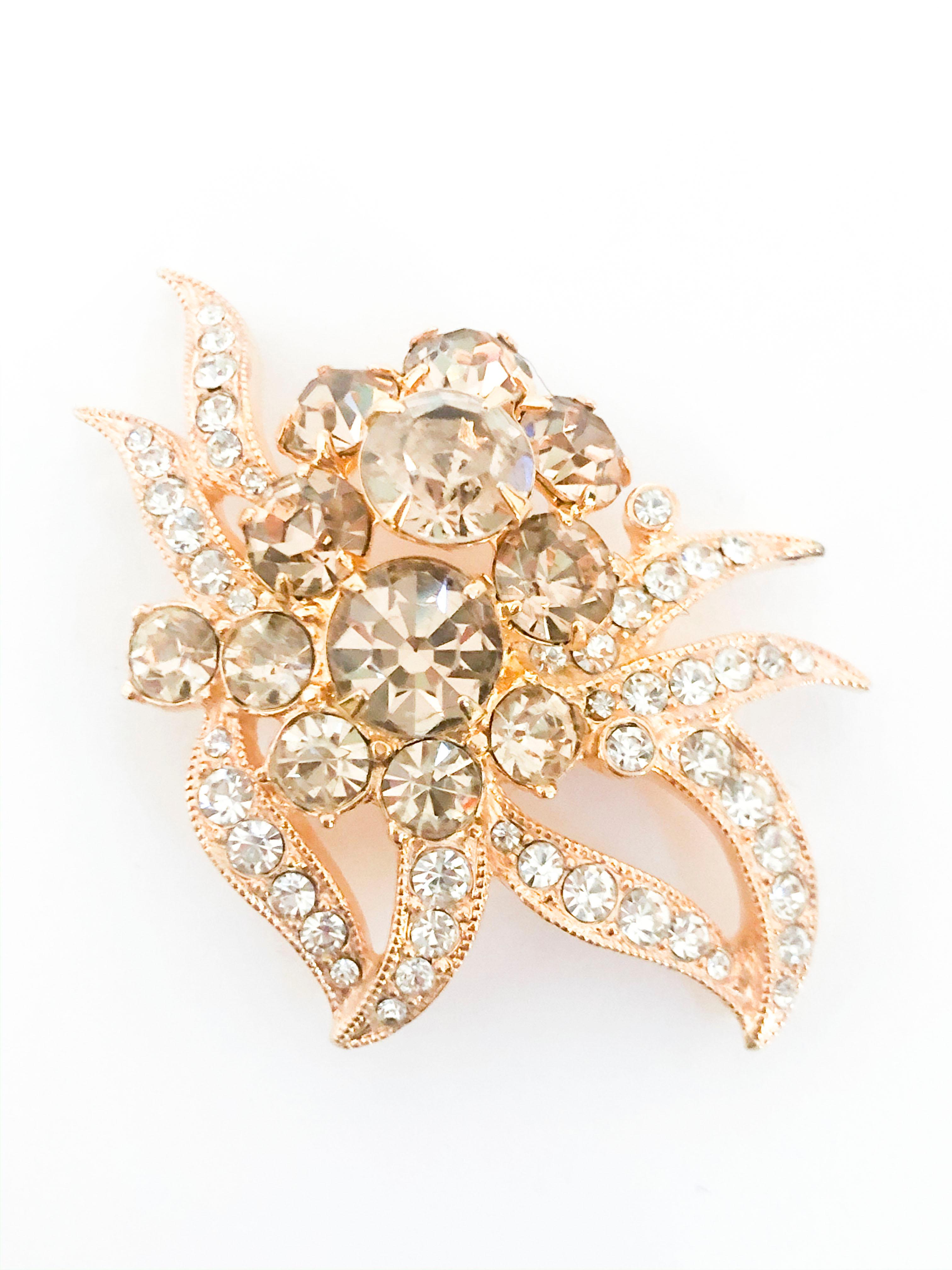 1950s Eisenberg brooch featuring large light gold-tinted rhinestones complemented with multi-cut small rhinestones all set in a gold-wash setting metal. the back has a short brooch pin and hallmarked with 