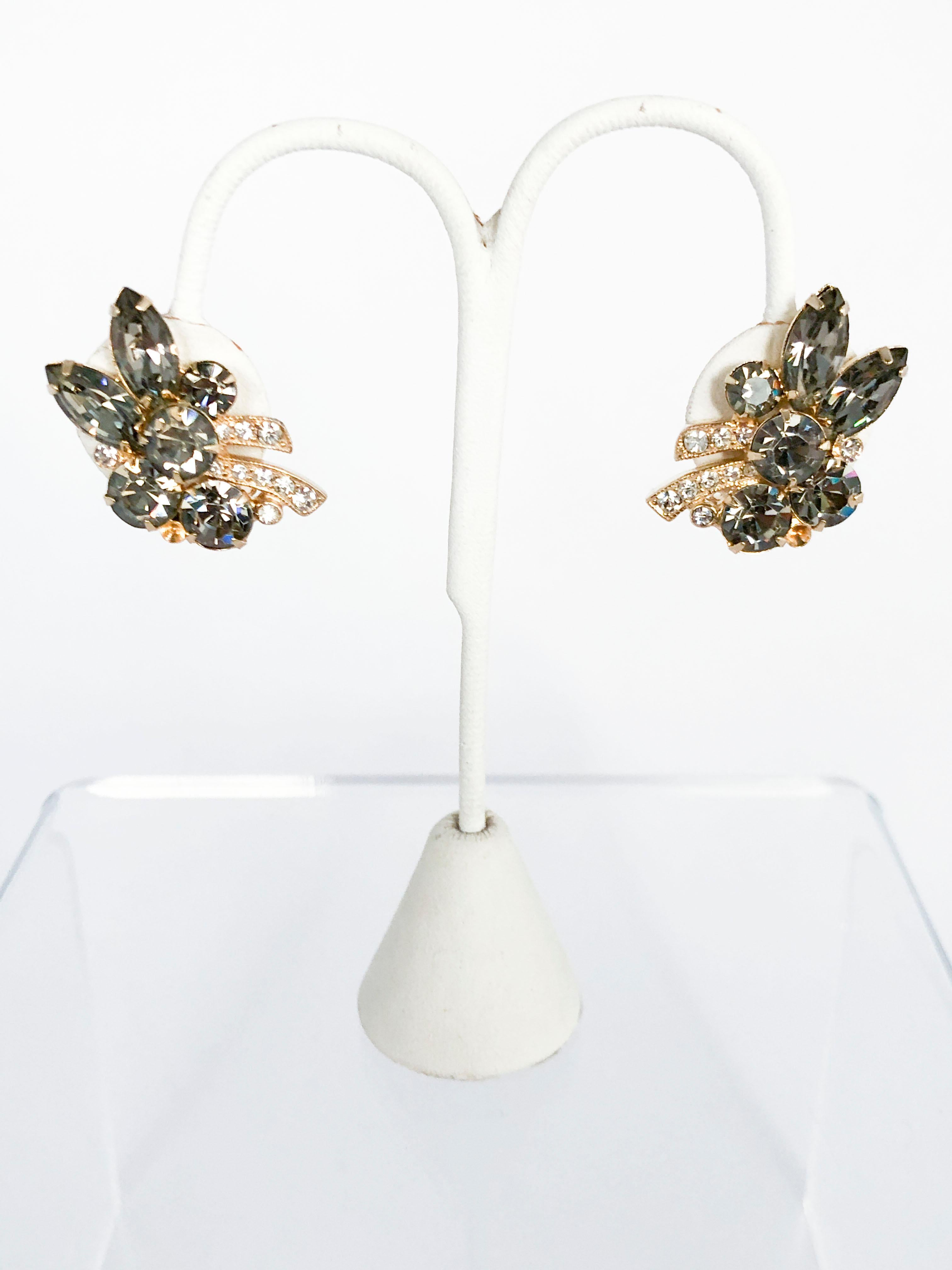 1950s Eisenberg brooch and clip-on earring set. The smoky grey and clear multi-cut rhinestones are set in a gold-wash base metal. The back of the brooch has a standard brooch pin and clearly displays the Eisenberg hallmark.