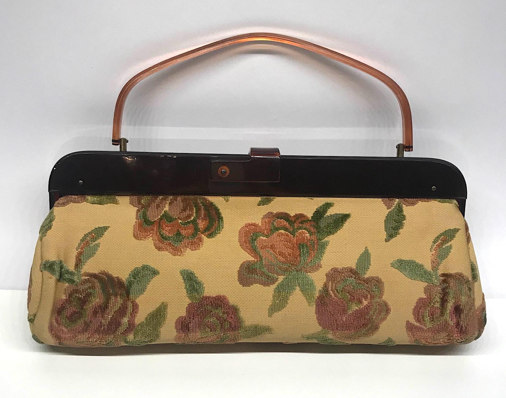 A marvelous example of a 1950s mid century hand bag in cut velvet fabric. The body is elongated measuring just under 16 inches in length, 4.75 inches wide and 6.5 inches high not including the handle. With the handle up the height is 11.5 inches.