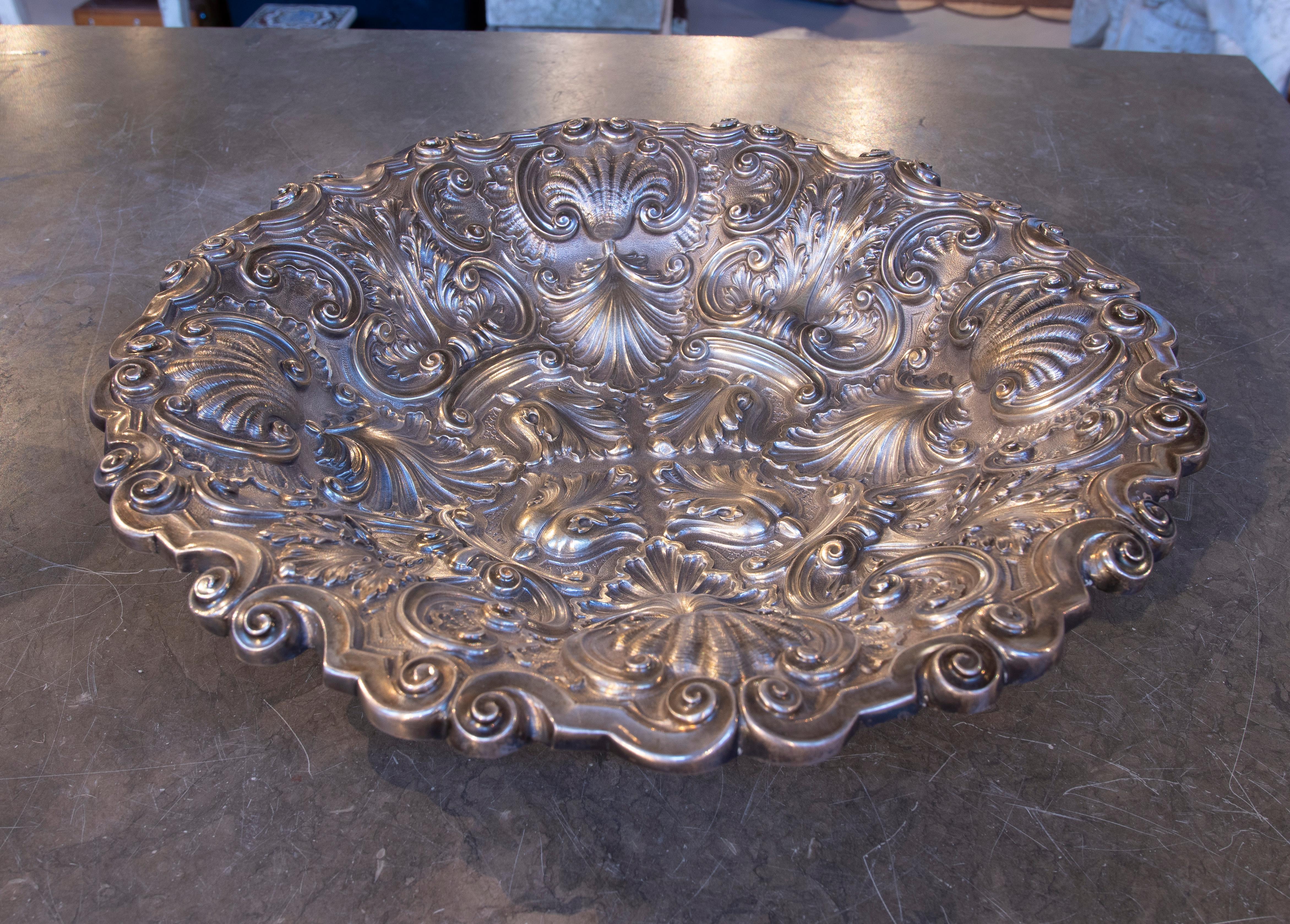 Elegante fontana in metallo con un intricato disegno in rilievo in stile barocco. I rilievi dettagliati di foglie e volute creano una texture sofisticata e lussuosa, mettendo in risalto l'abilità artigianale. Ideale come pezzo decorativo, come