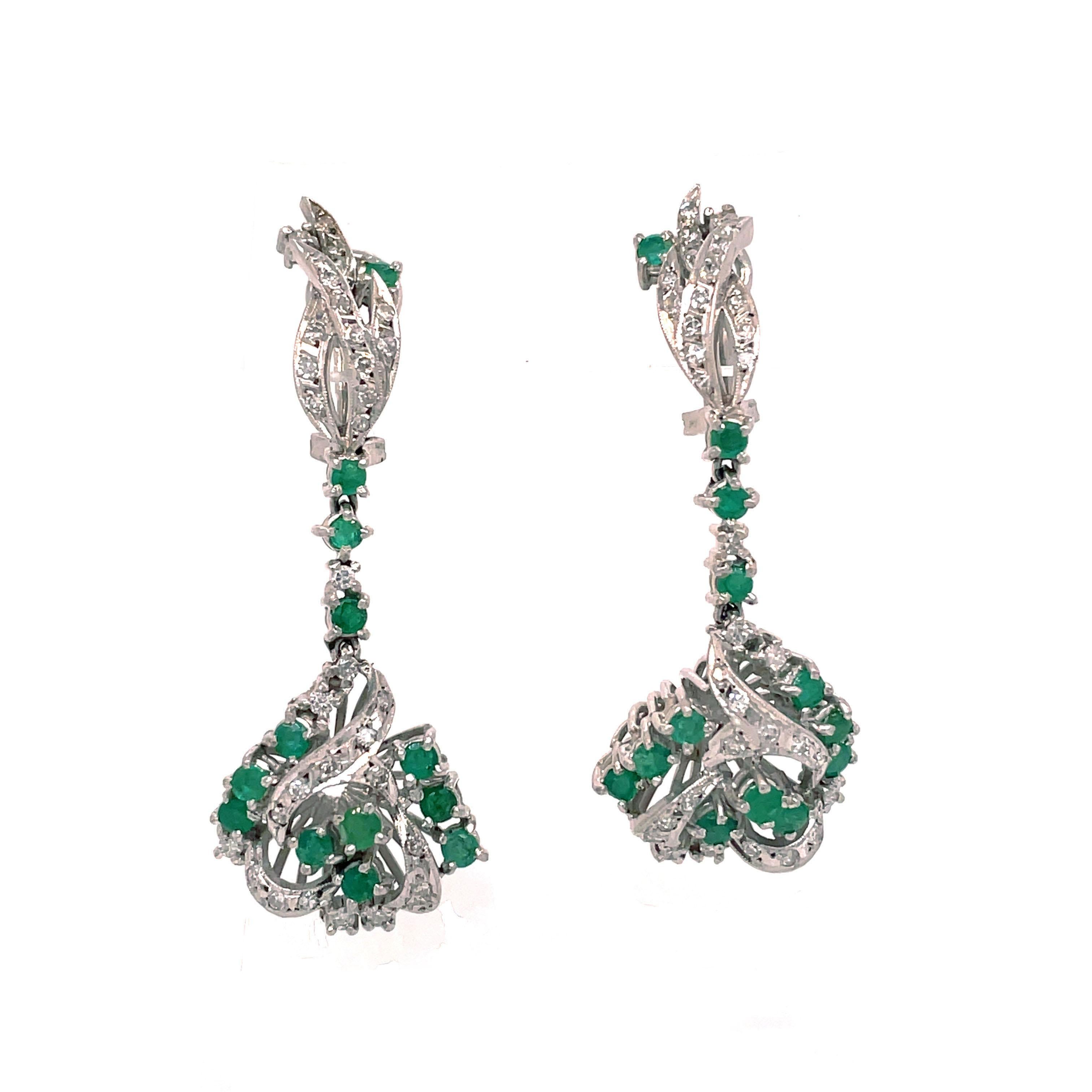 This is an alluring pair of 1950s dangle earrings that feature a beautiful array of round emeralds and diamonds encased in platinum. You truly will not find a pair of earrings quite like these beauties. Just upon first glance, the earrings are