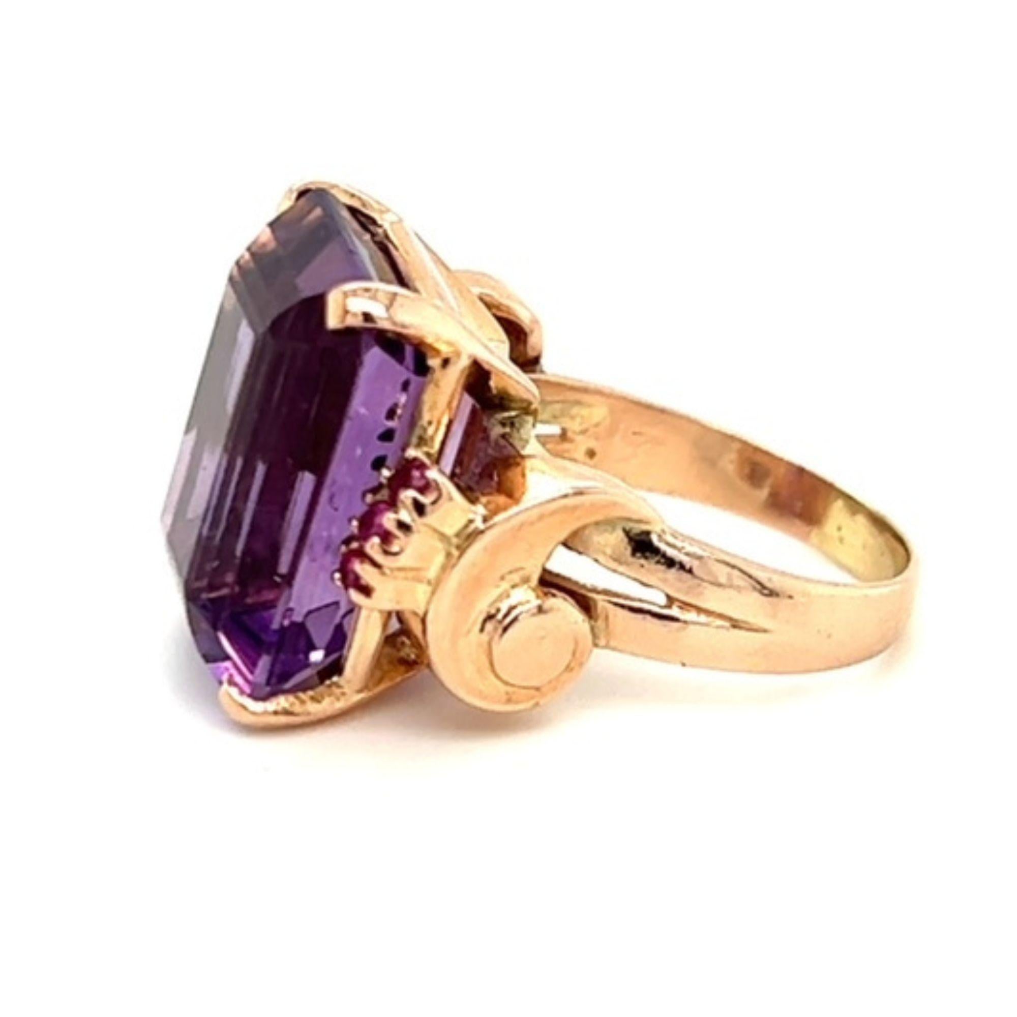 One 14 karat rose gold retro design ring set with one 18.5x14.7mm emerald cut amethyst, flanked by six (6) 2mm round rubies. The ring is a finger size 7.5 and can be resized, however resizing is not included.  The shank is stamped 14K and the ring
