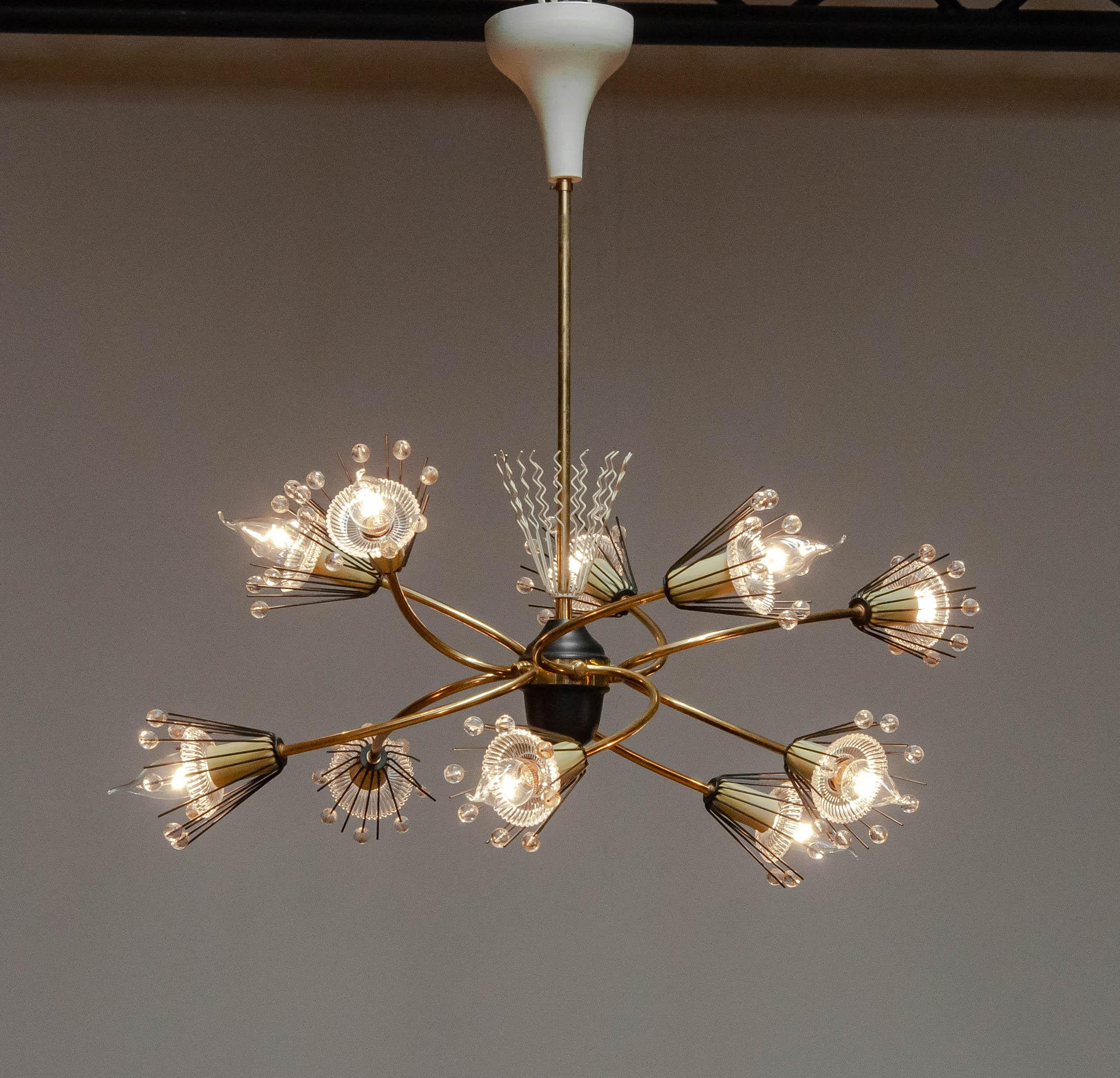 Beautiful 1950s brass with black lacquered details 'Snowflakes' or 'Pyra' chandelier designed by Emil Stejnar for Rupert Nikoll in Vienna Austria. This example has ten arms is is in complete condition meaning that all ten art glass dishes ( behind