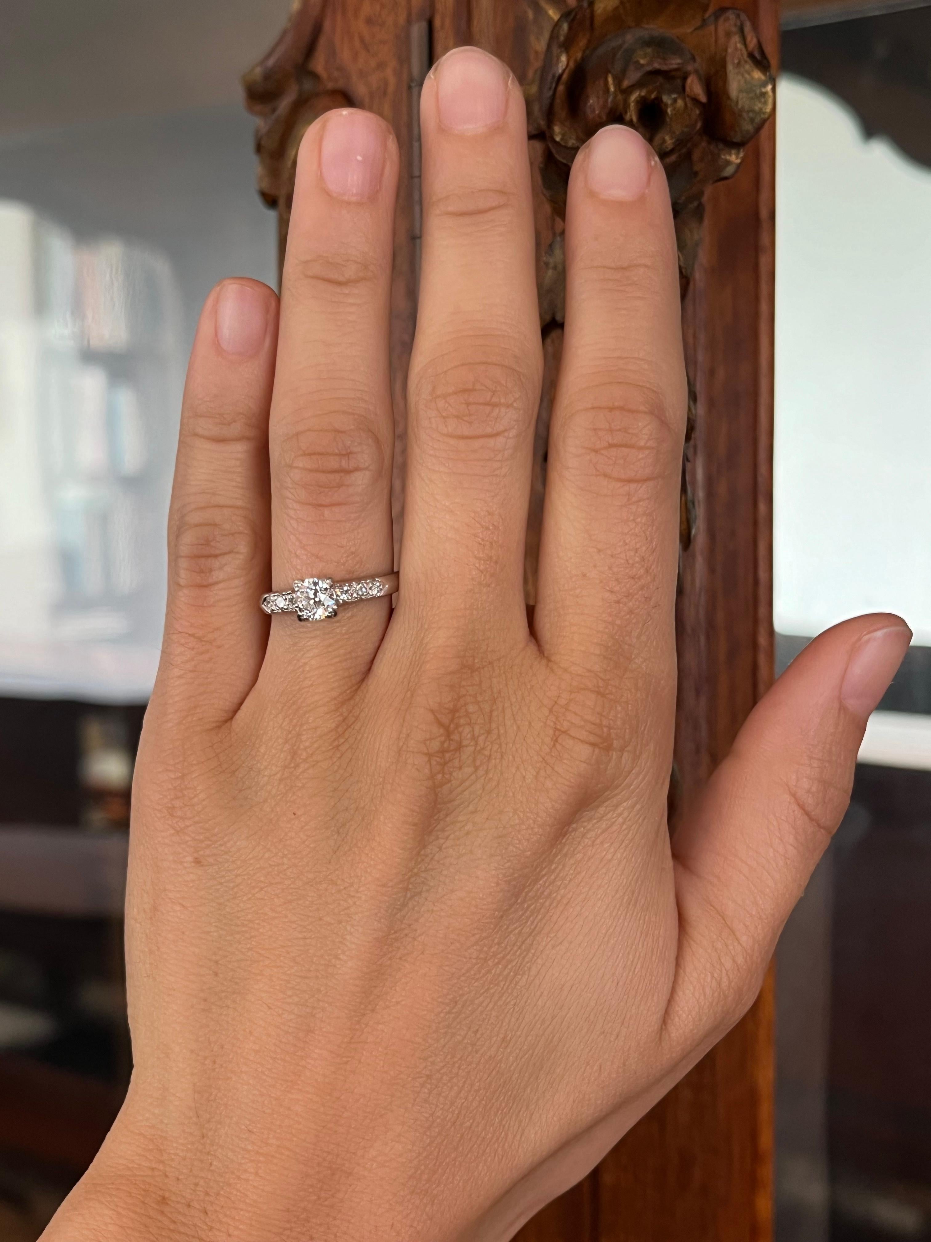 Un héritage d'une élégance durable. Cette bague de fiançailles en platine des années 1950 est ornée d'un diamant central de taille européenne ancienne de 0,50 ct, flanqué de six diamants étincelants de taille normale (0,12 cttw). Avec sa symétrie
