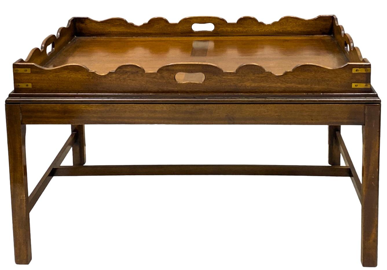 This is an English campaign style banded mahogany butler tray top coffee table. The tray is not attached. Note the brass reinforced corners. It is a handsome timeless piece. 