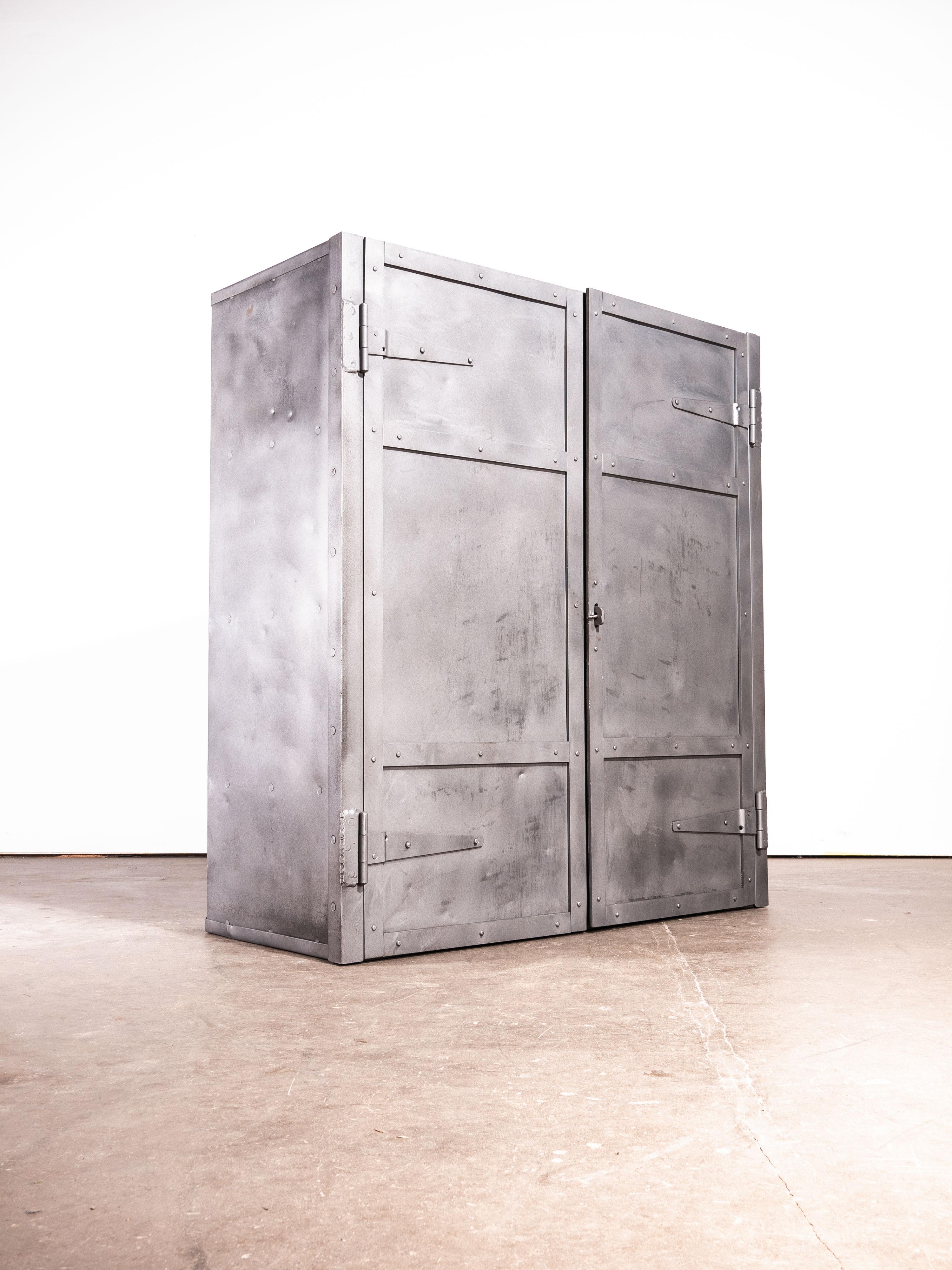1950s English industrial metal storage cabinet, cupboard. Sourced from a steel foundry outside Manchester this well proportioned heavy duty cabinet was used to store the metal workers tools. Internally the shelves are at fixed heights although