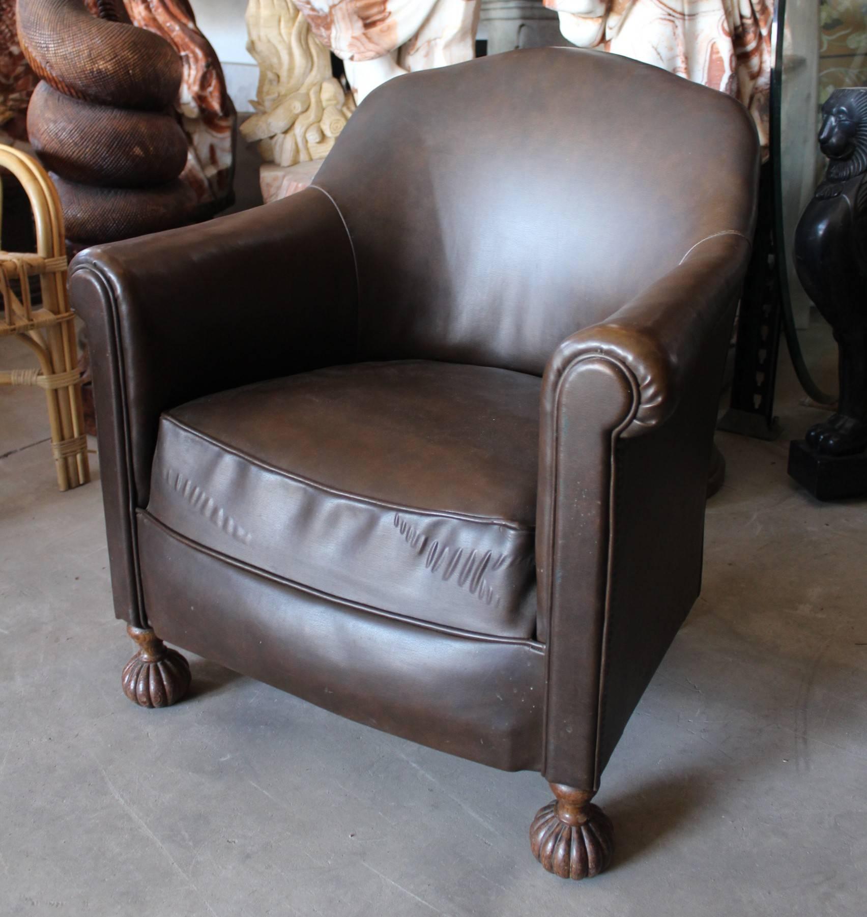 1950s English leather armchair with hand-carved wooden globular legs.
   
