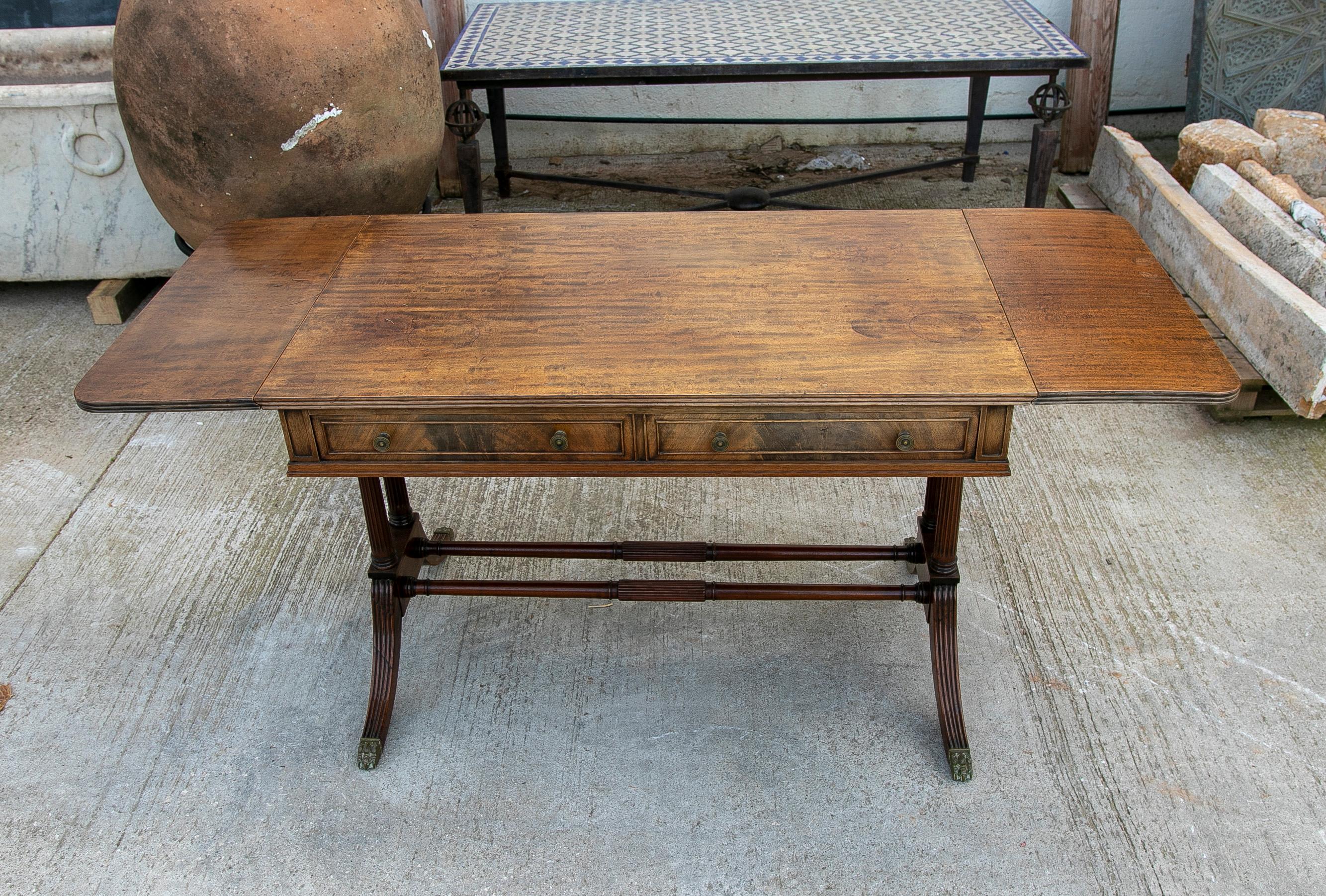English 1950s mahogany writing table with drawers and legs with bronze lions claws.
Dimensions open table: 74 x 165 x 66cm.