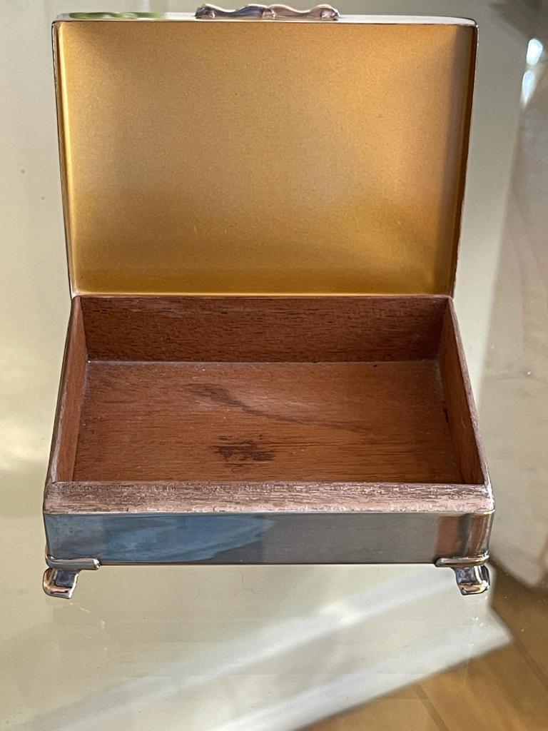 Silver-plated cigarette or cigar box handcrafted by notable silversmith the Harman Brothers in England in the 1950s. Delicately crafted with raised feet, lined with wood and flower hand engravings. Can be re-used as a decorative or jewelry box.
