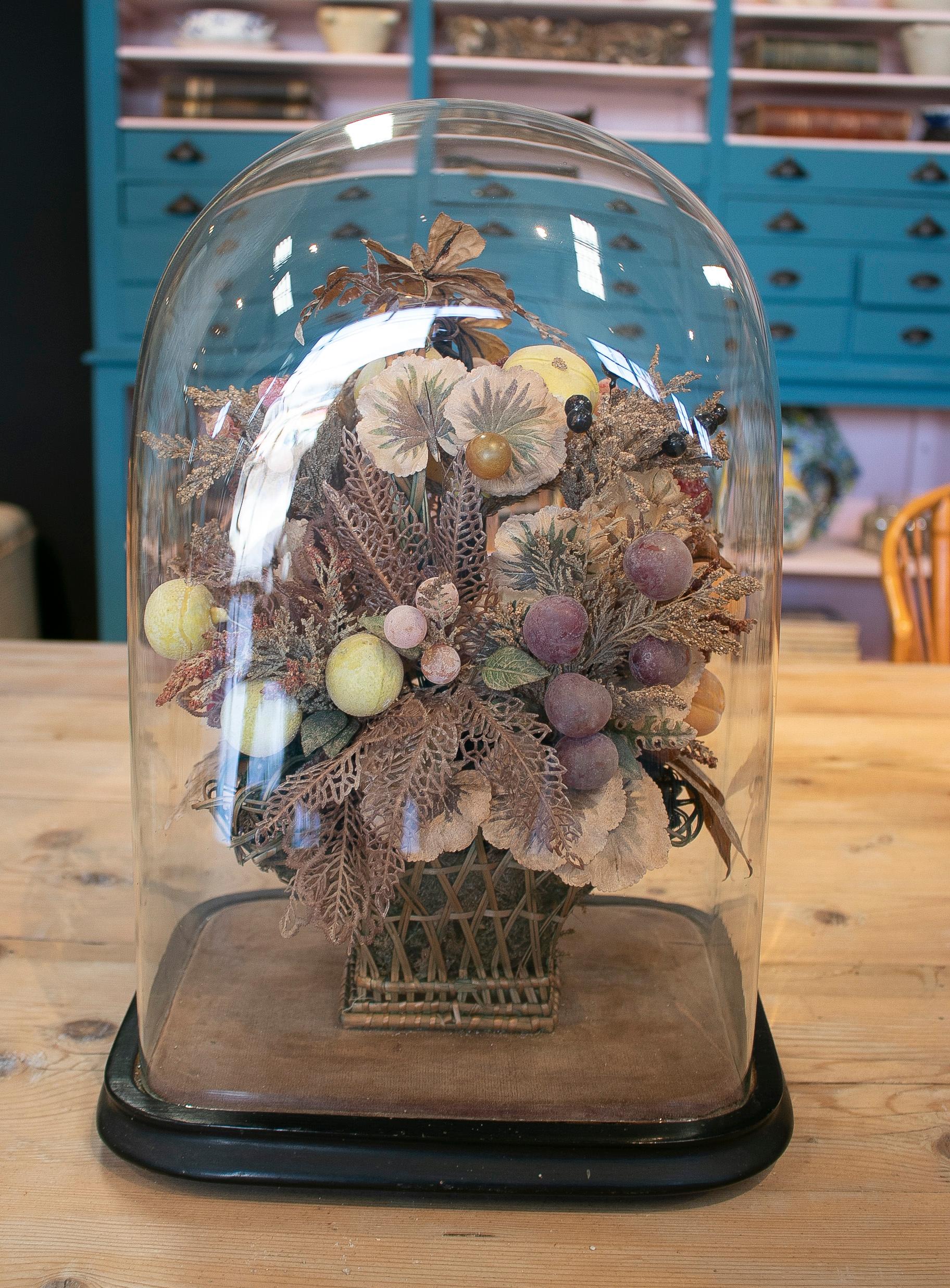 Vintage 1950s English Victorian woven wicker and plastic basket with flower bouquet under glass dome.