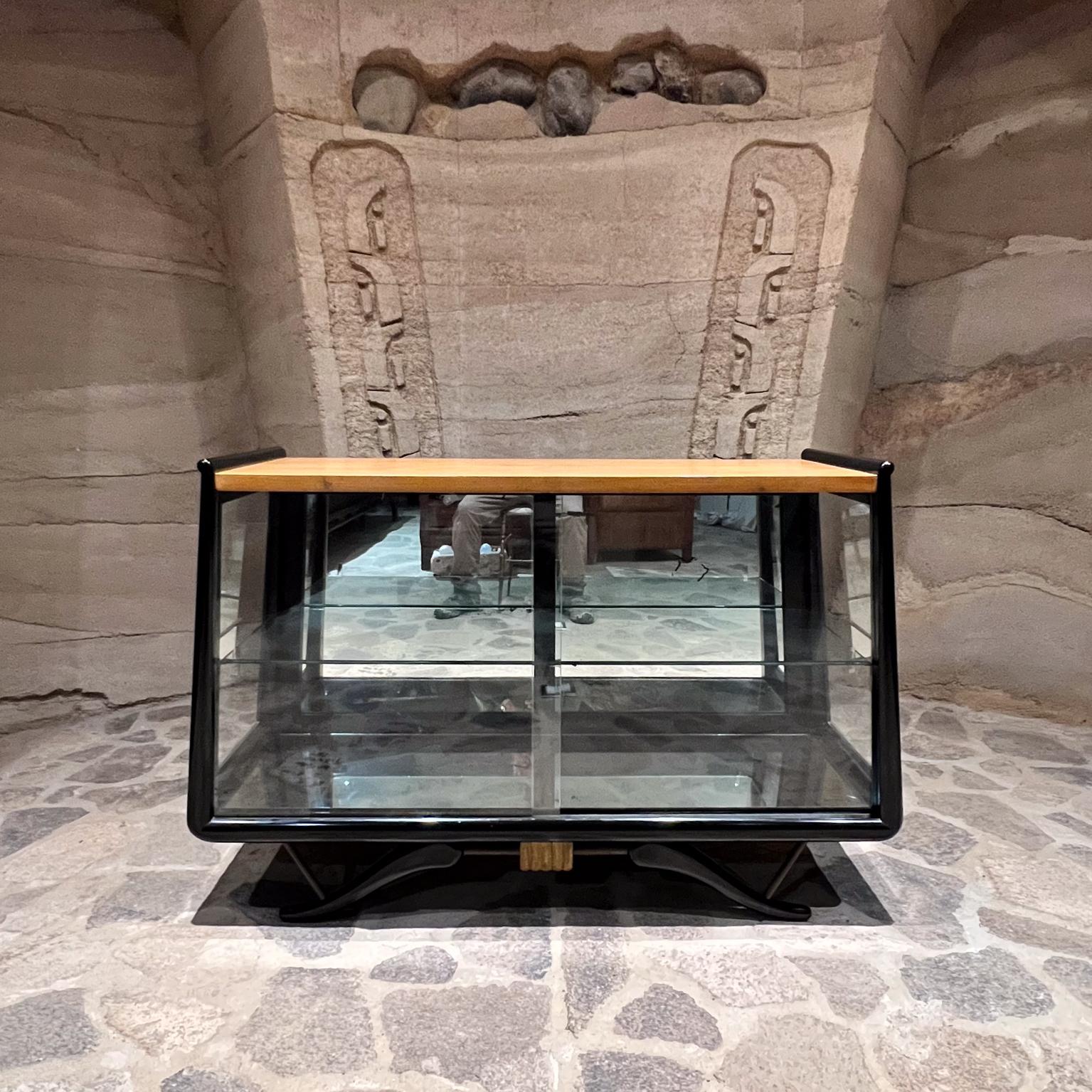 Pour votre considération, un modèle d'Eugenio Escudero des années 1950
Vitrine acajou en verre doré Vitrine d'exposition.
Non marqué.
Acajou massif laqué noir.
Portes coulissantes latérales et frontales en verre. L'intérieur est doté d'un mur en