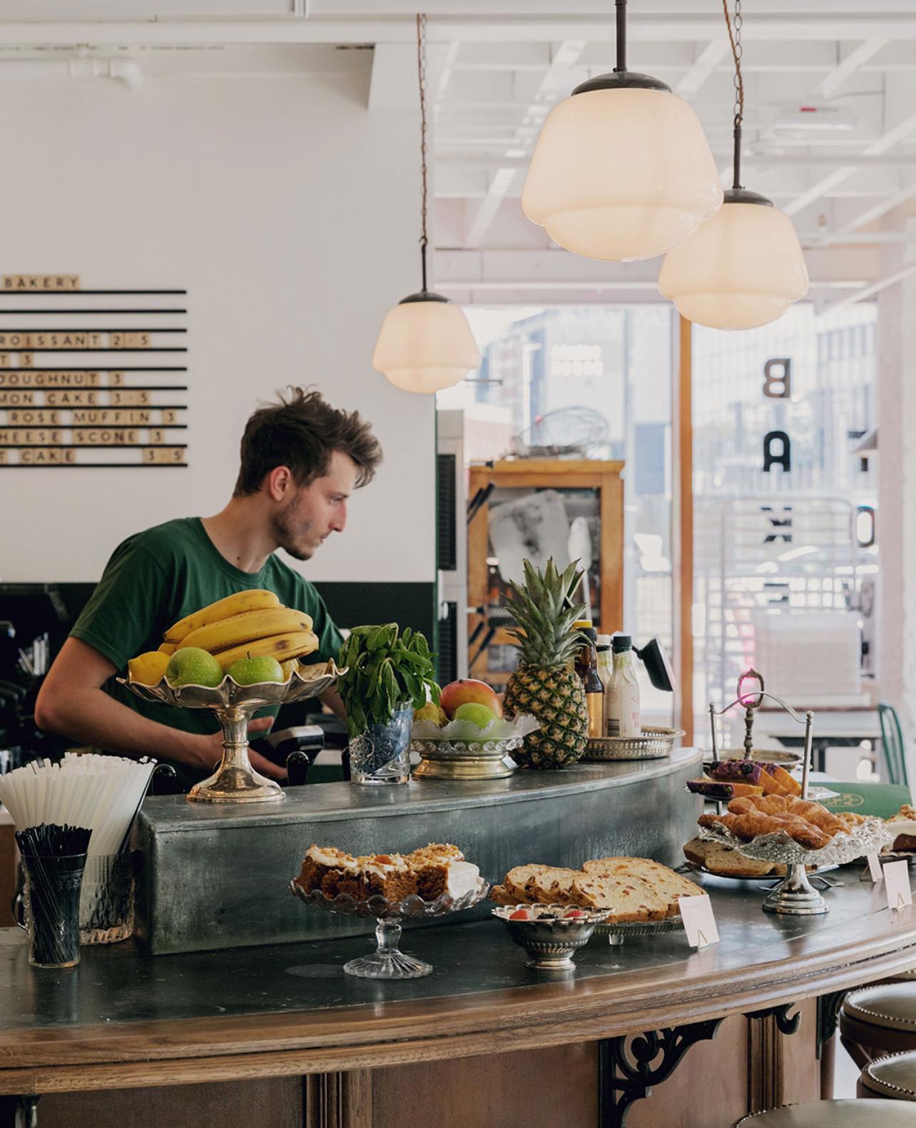 Un'elegante lampada a sospensione della metà del secolo scorso con un paralume in vetro opalino bianco a più livelli sospeso dalla sua galleria originale in bachelite nera. La forma a gradini del diffusore in vetro produce un'illuminazione morbida e