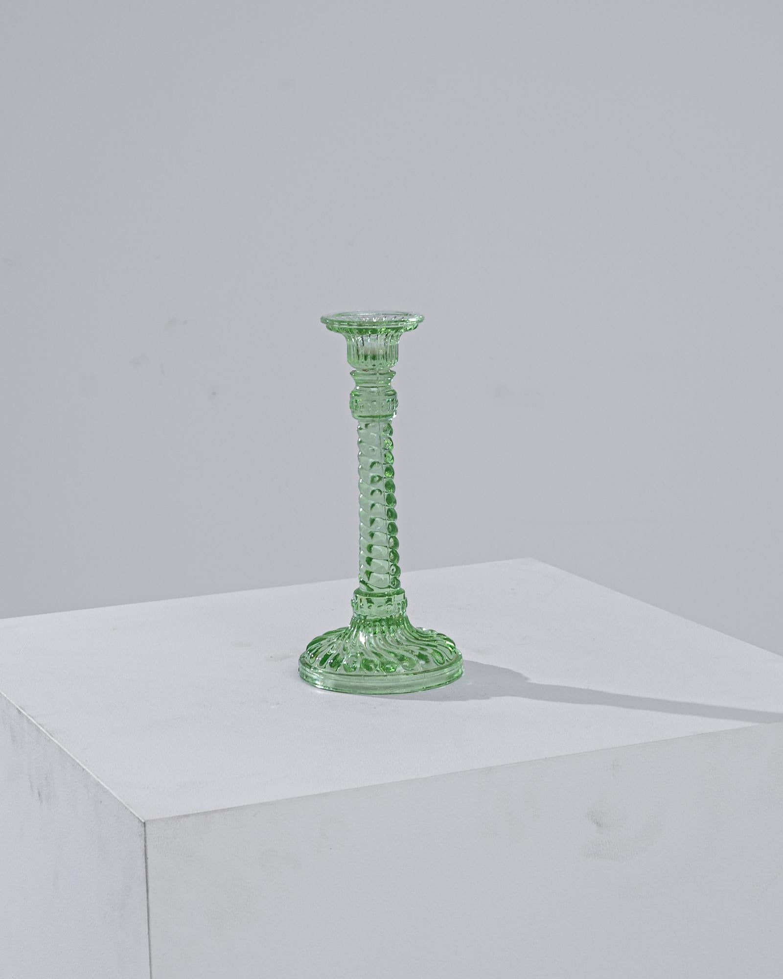 Add a touch of vintage charm to your table setting with this exquisite 1950s European green glass candlestick. Crafted with impeccable attention to detail, this piece radiates with a vibrant green hue, capturing the essence of mid-century elegance.