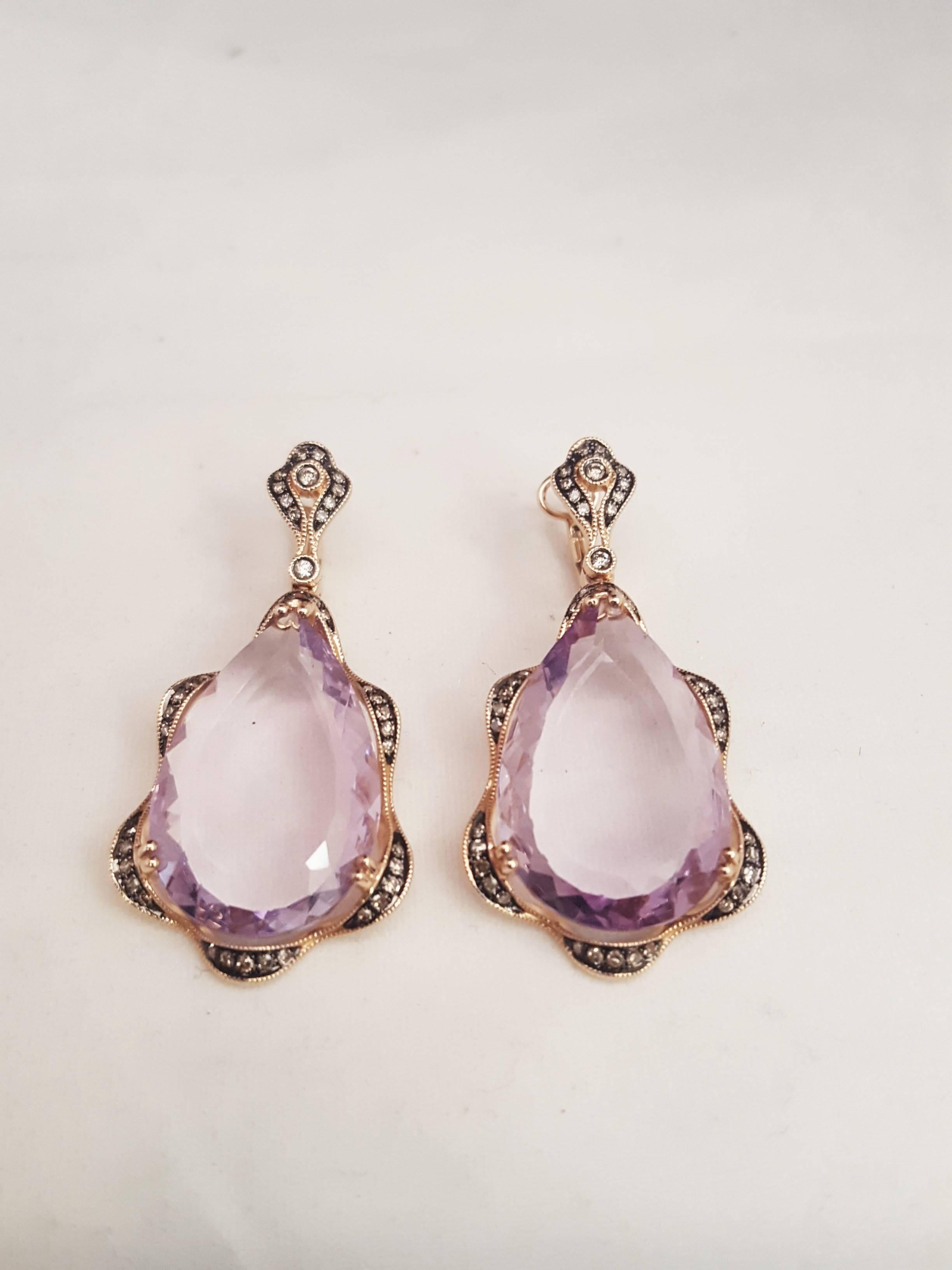 The distinct look of old world beauty!  Beautifully designed in 14 karat rose gold, these drop earrings are absolutely stunning!
An impressive 11mm x 20mm checkerboard side faceted amethyst being the focal point.  Framework boasts milgrain edges