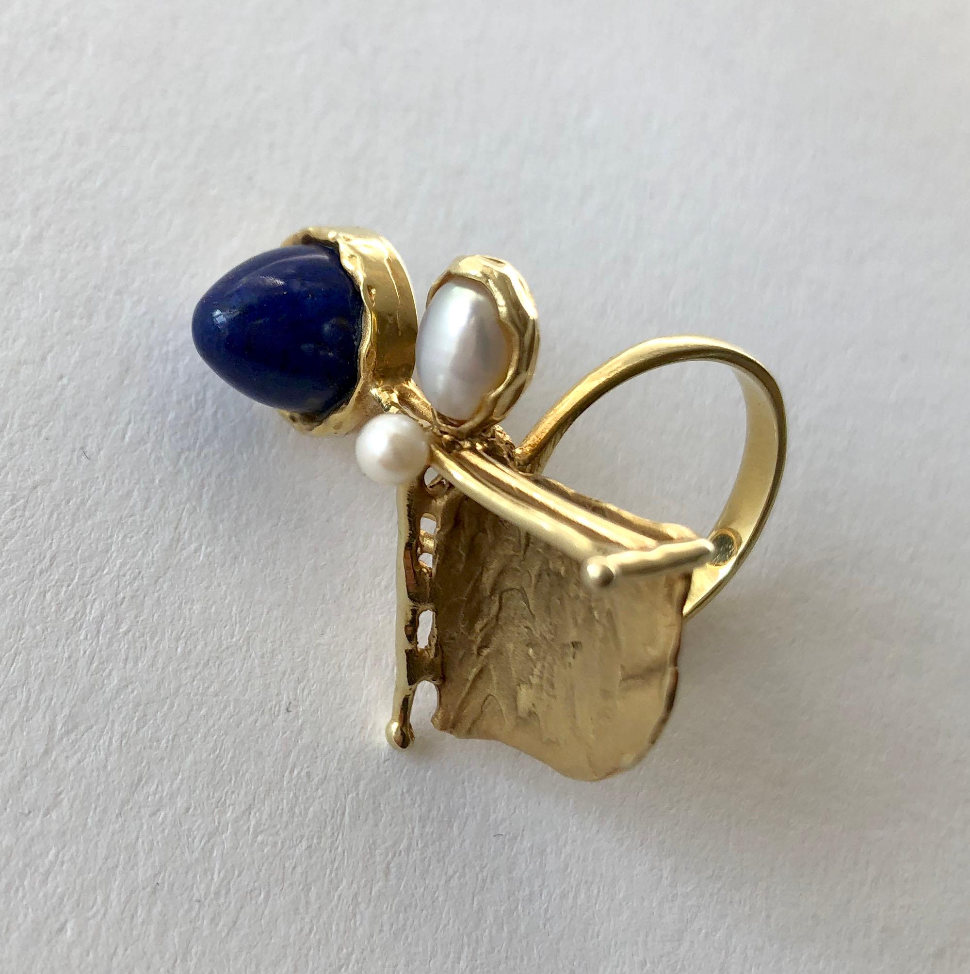 1950's European modernist 14ct gold ring featuring a conical cut bezel set lapis lazuli with mabé grey pearl accent.  Ring is a finger size 7.5 and is signed 14 ct.  In very good vintage 1950s condition.  8.7 grams.