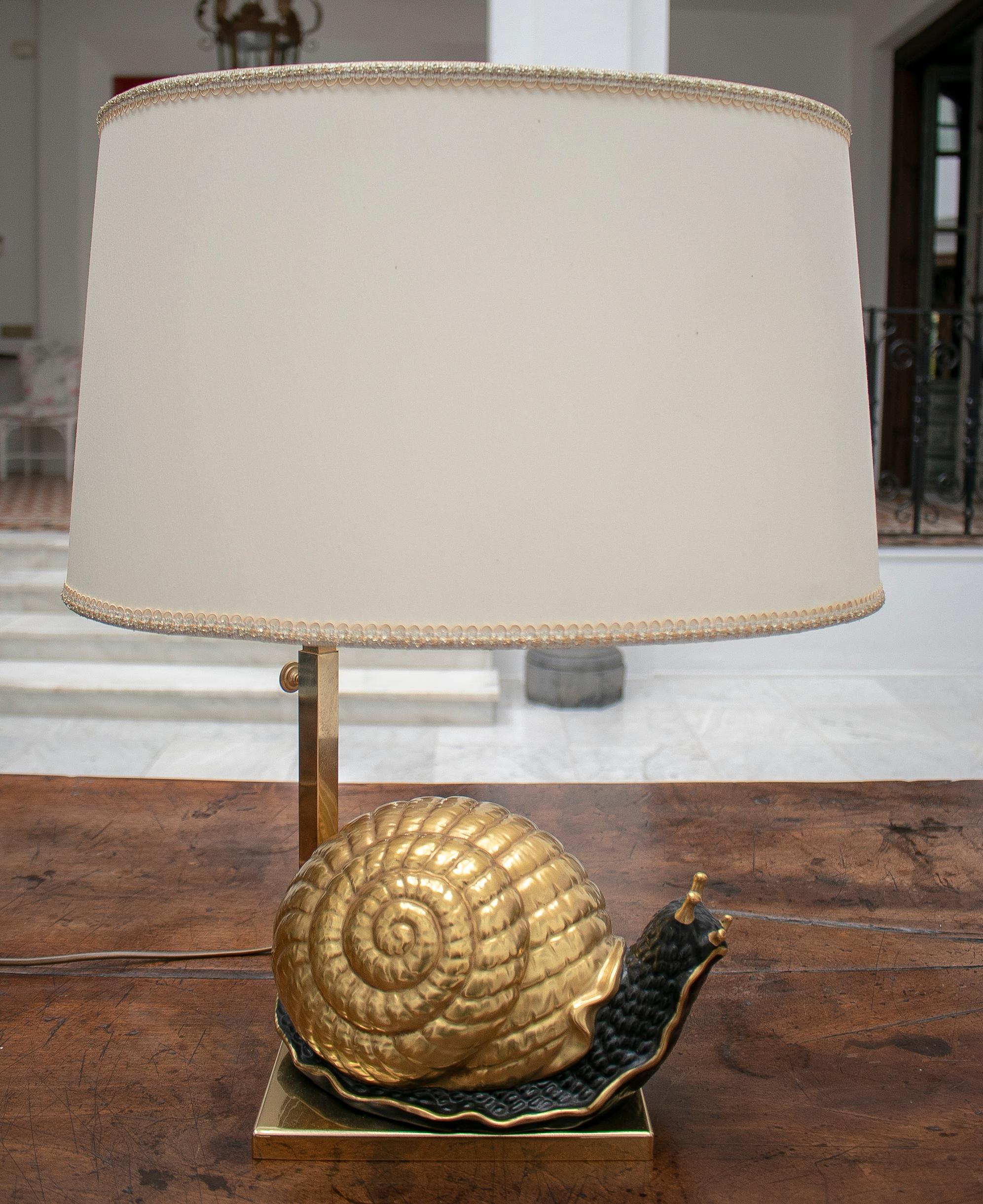 Lampe européenne des années 1950 en forme d'escargot en terre cuite avec base et abat-jour en bronze.