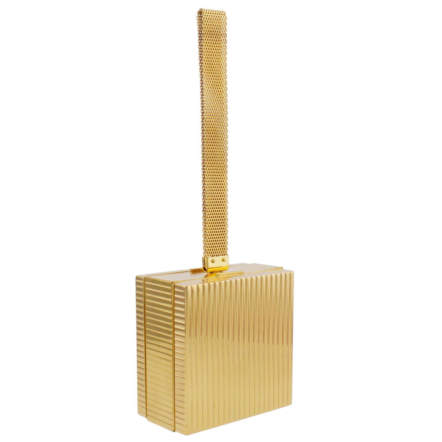 Unused and in original condition Evans evening minaudière from the 1950s. Square shaped ribbed gold tone metal with a gold metal mesh loop wristlet strap. Press lever mechanisms open each side. One side features all the 1950s make up compartments