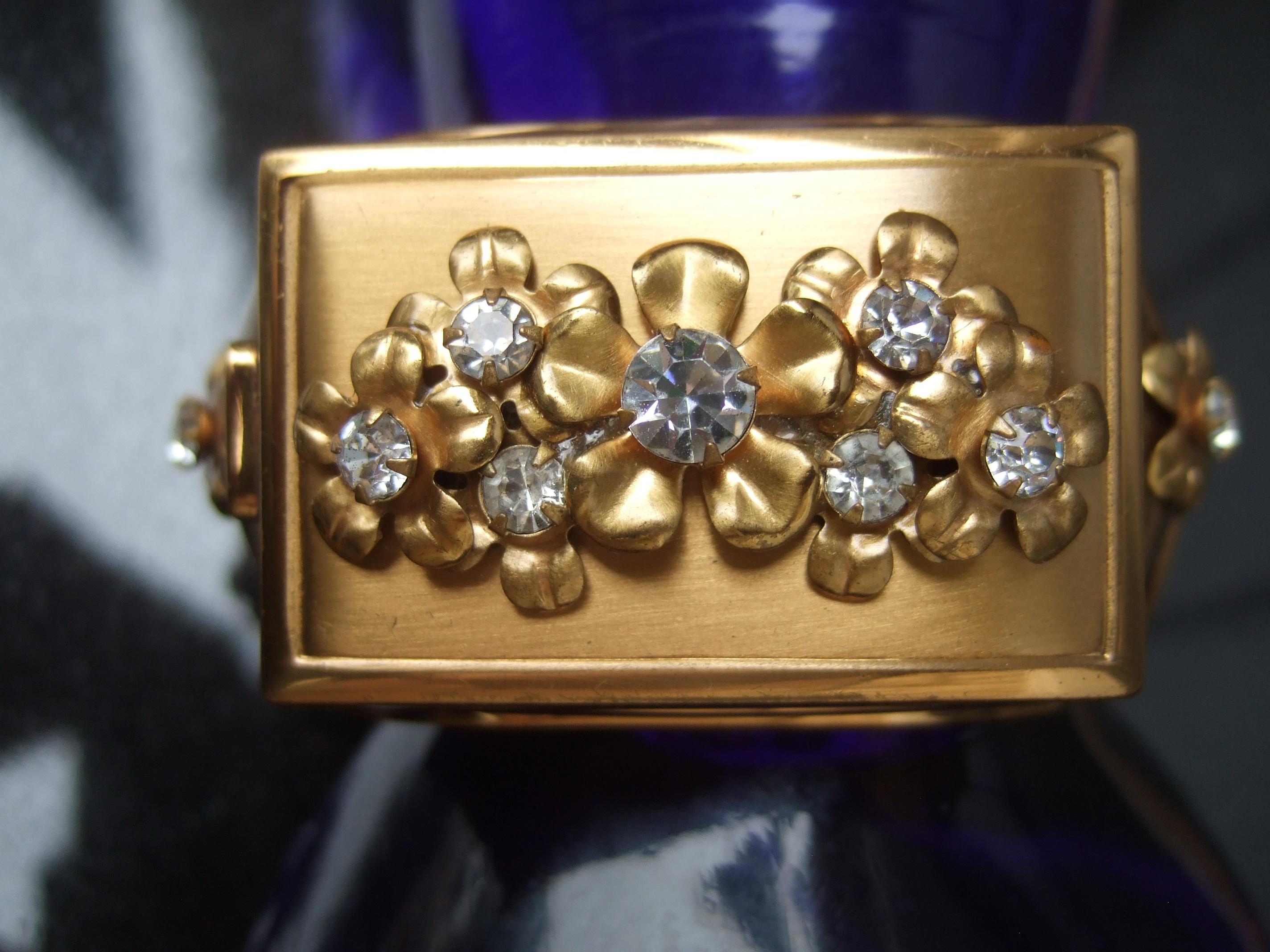 1950s Extremely rare art deco jeweled vanity compact wide hinged cuff bracelet 
The elegant sleek gold plated hinged cuff is designed with a jeweled lidded vanity compact 
with a small vanity mirror & small rouge compartment 

The hinged compact lid