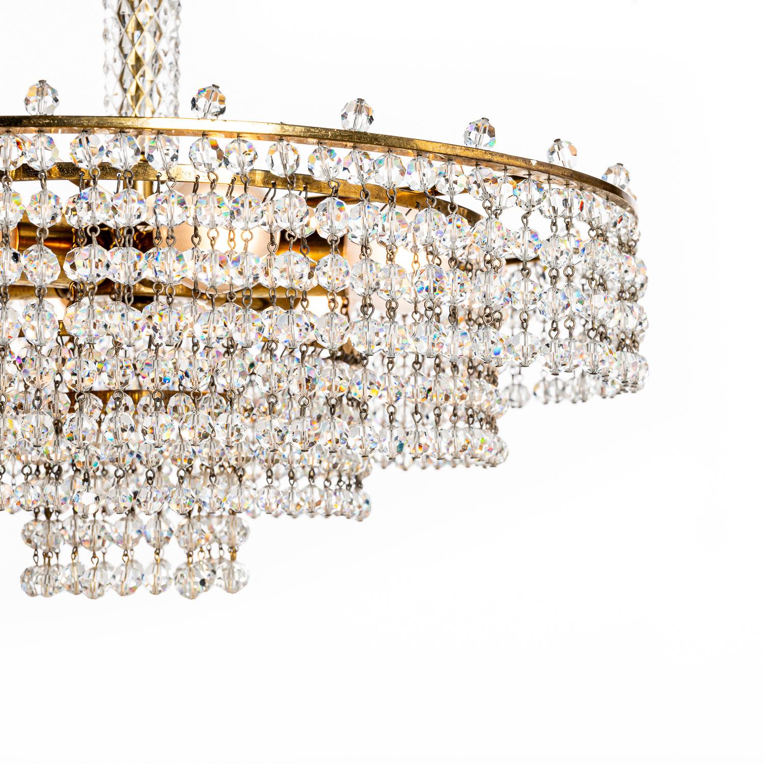 This is a wonderful design attributed attributed to Lobmeyr. Stunning crystal glass and patinated brass chandelier. The combination of these materials expertly crafted give this piece a real ritzy feel. Made in the 1950s, it’s still in beautiful