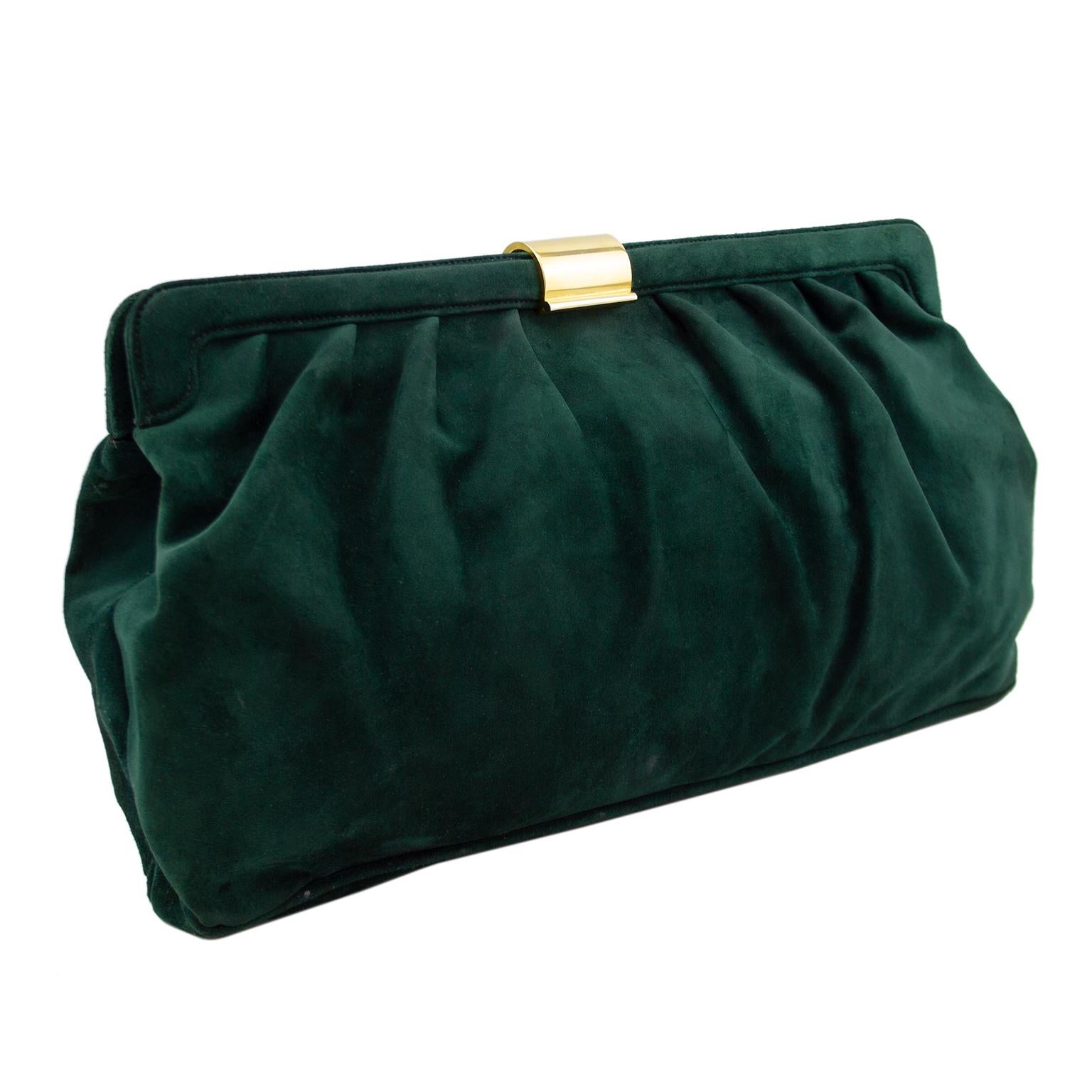 Stunning oversized Salvatore Ferragamo soft clutch from the 1980's. The deep and rich dark green suede is perfectly contrasted by the warm gold tone metal hardware. Rectangular frame style with gathering. The gold tone closure lifts up to open the