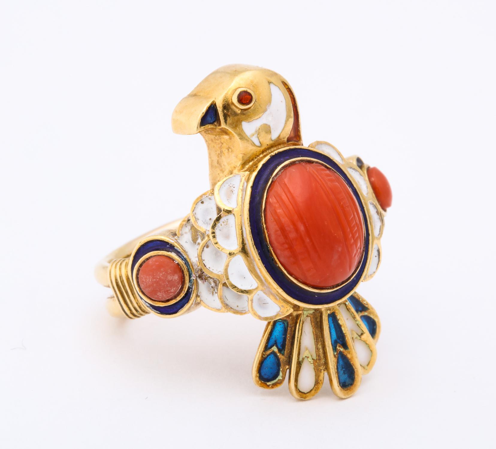 One Ladies 14kt Yellow Gold Ring Designed With A Figural Bird Motif. Bird Is Embellished With A 13mm Carved Coral Stone. Bird Ring Is Further Designed With Blue And White Enamel And With A Cabochon Ruby For His Eye. Ring Is Further Flanked With @