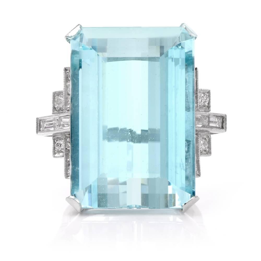 This stunning vintage ring circa1950's chic and stylish ring to own! Finely crafted in platinum, this ring features 1 genuine emerald cut aquamarine approx. 36.0 carats. 16 genuine round diamonds and 4 baguette-cut compliments the gorgeous sky blue