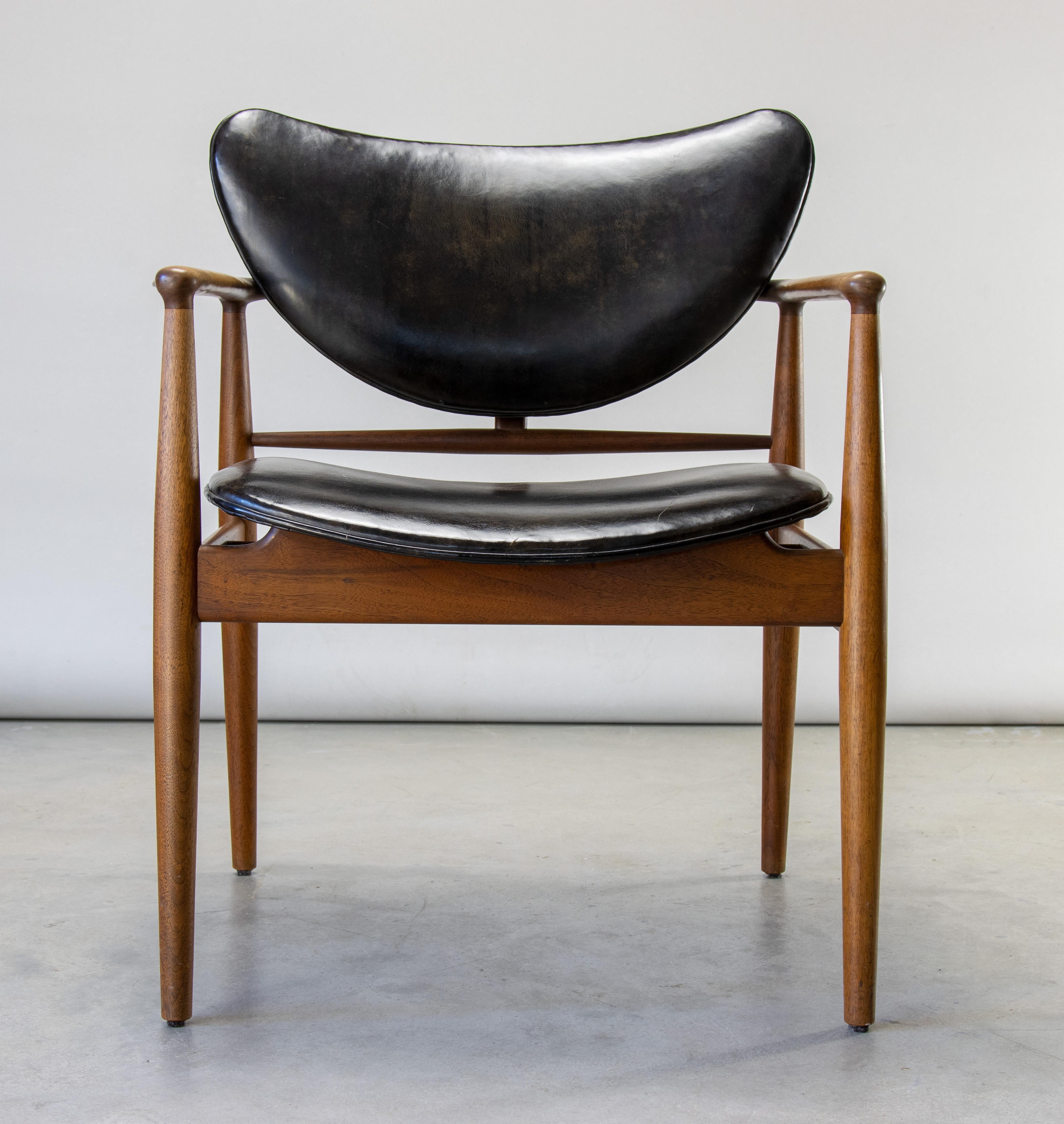 The no. 48 armchair designed by Finn Juhl, produced by Baker in the 1950s. This example showing a gorgeous patina to the leather. No cuts or tears. Nice warm patina to the highly figured walnut. Brass spacers float the back from the walnut frame and