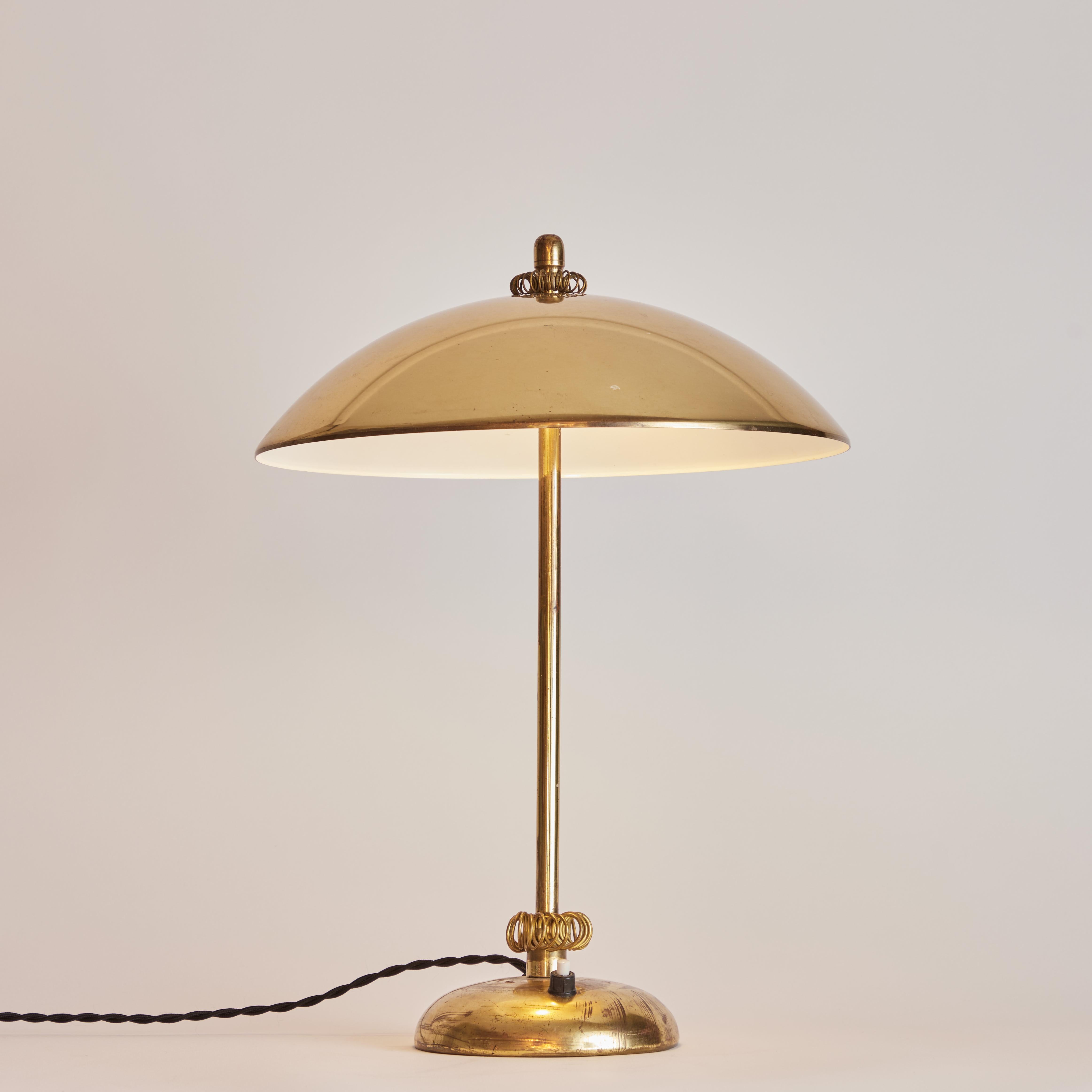 1950s Finnish brass table lamp Attributed to Paavo Tynell. An elegant design executed in attractively patinated brass and adorned with a pair of Tynell's trademark sculptural brass coils.

The undisputed master of Finnish lighting design, the