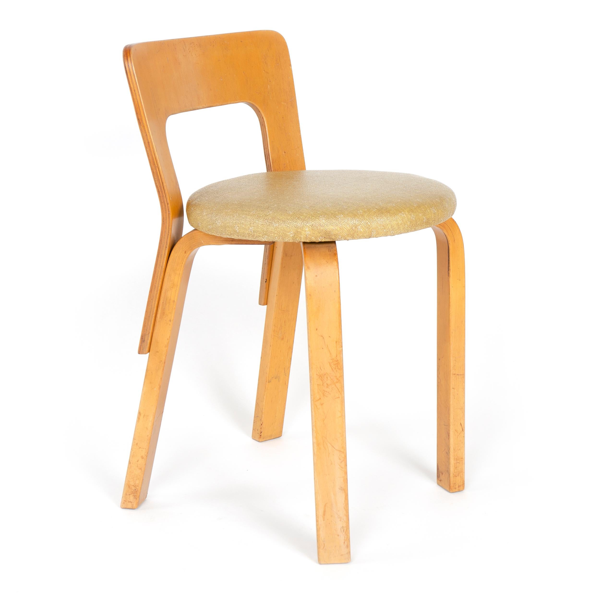 A post WWII edition of a 1935 Aalto design, model No.65, of molded and bent laminated Baltic birch. This particular low back side chair being a ‘rounded front’ version with upholstered seat. Legs have the Aalto inset splines at the bend of the legs.