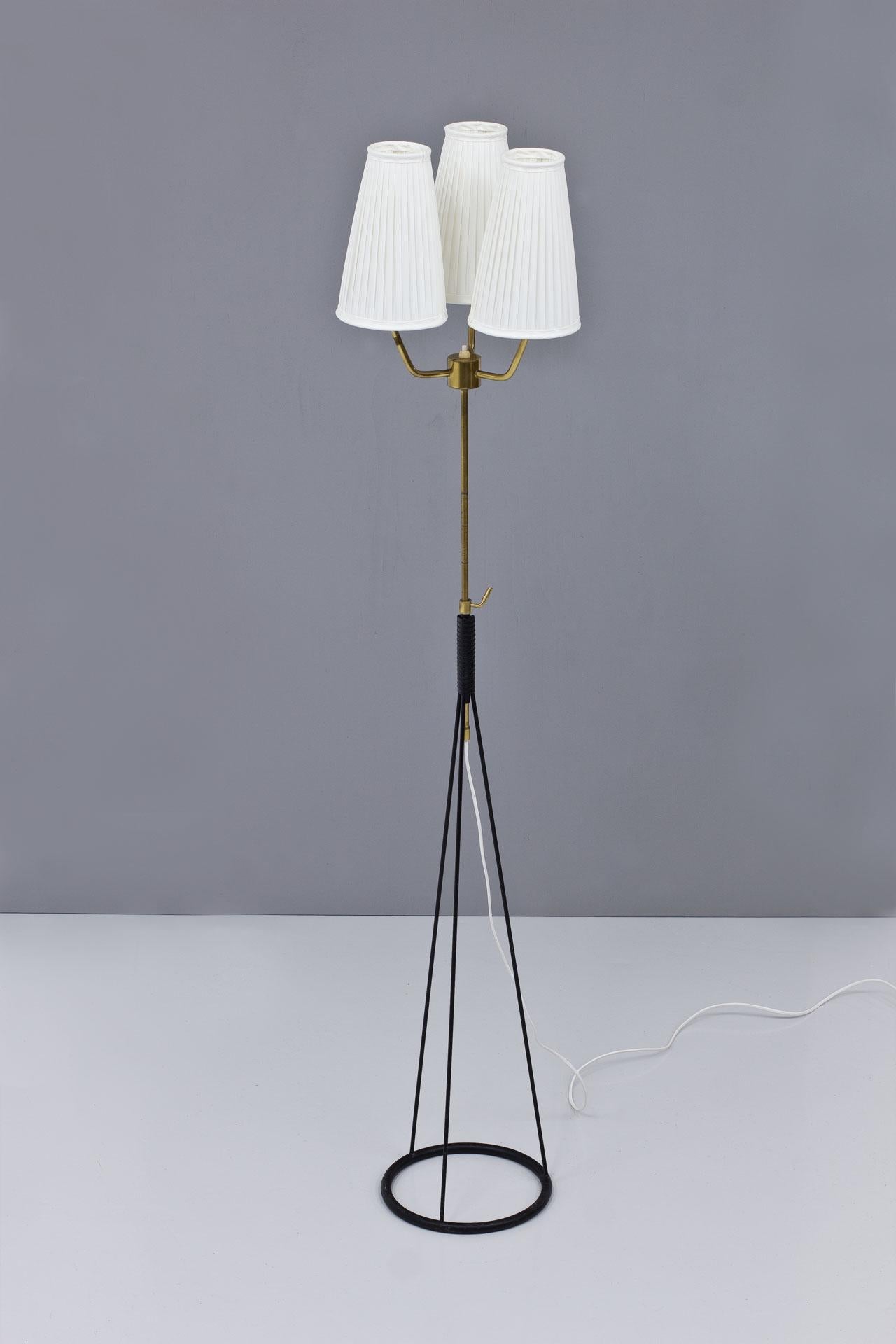 Rare floor lamp designed by Eje Ahlgren, manufactured by AB Luco in Göteborg, Sweden during the 1950s.
Black lacquered metal with brass stem. Original lampshades reupholstered in an off–white chintz pleated fabric. The stem has an adjustable